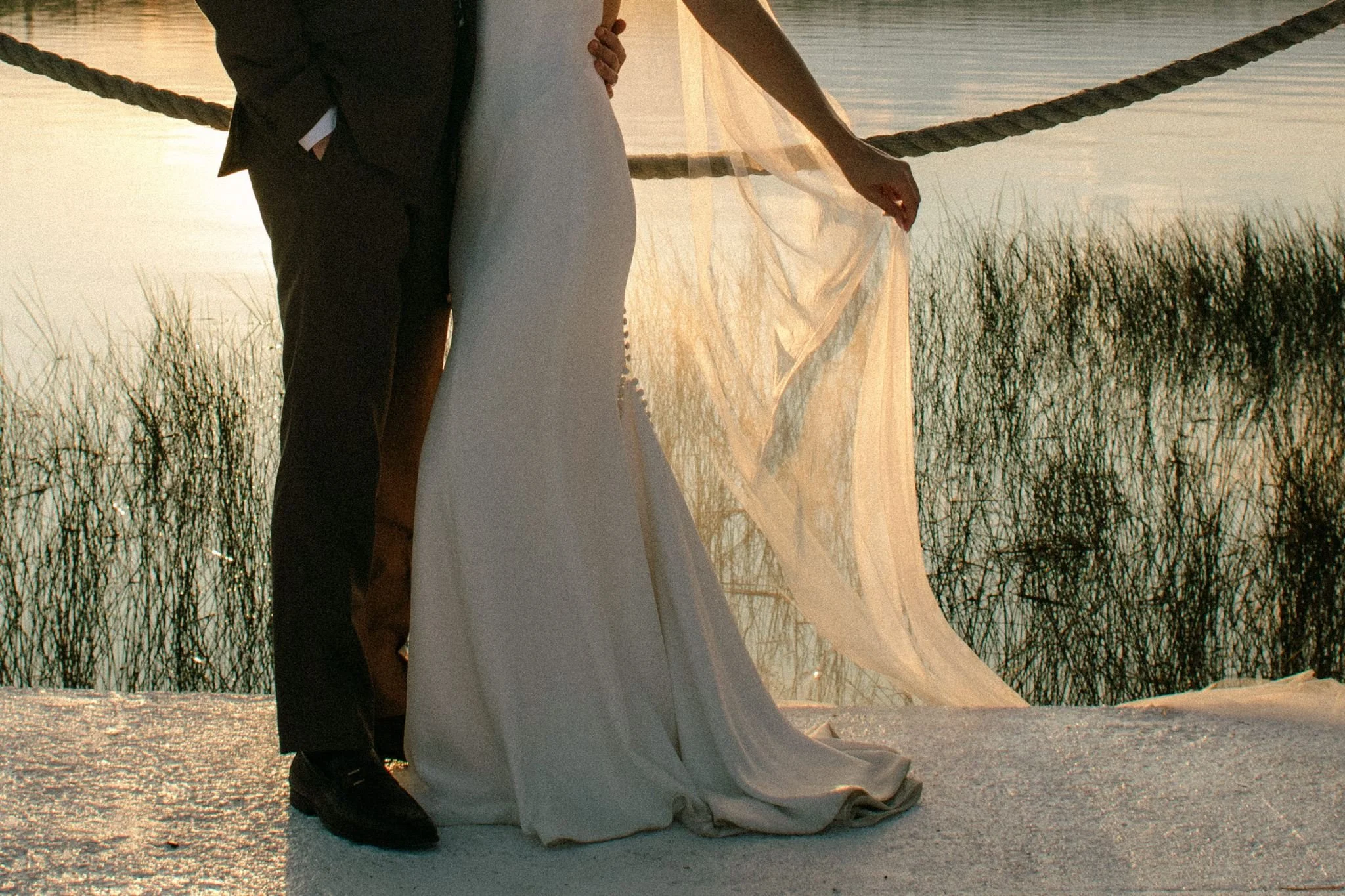 Golden light filters through bride's veil at Muskoka lake wedding