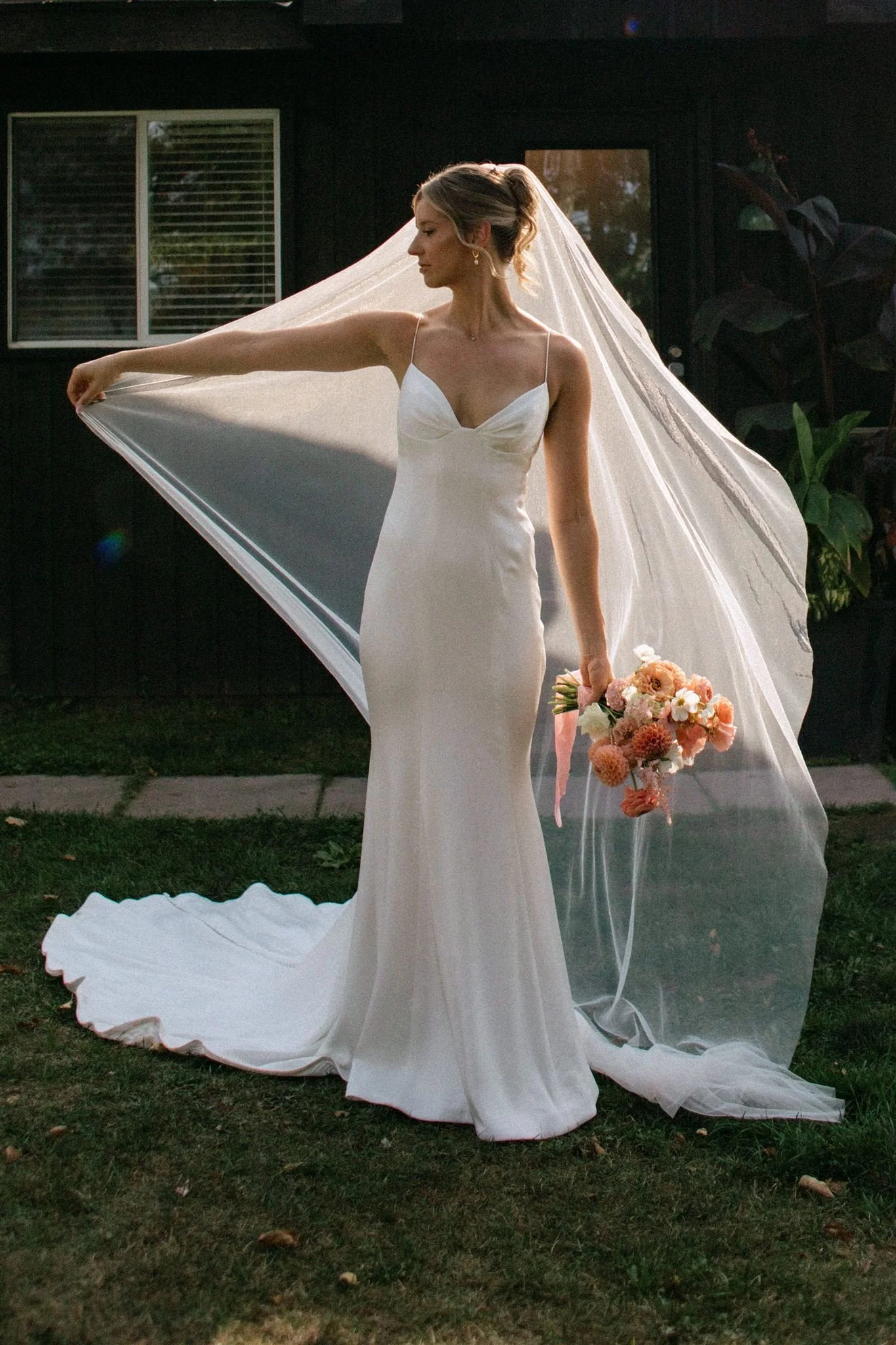 Backlit portrait of bride with veil and flowers at Northridge Inn wedding