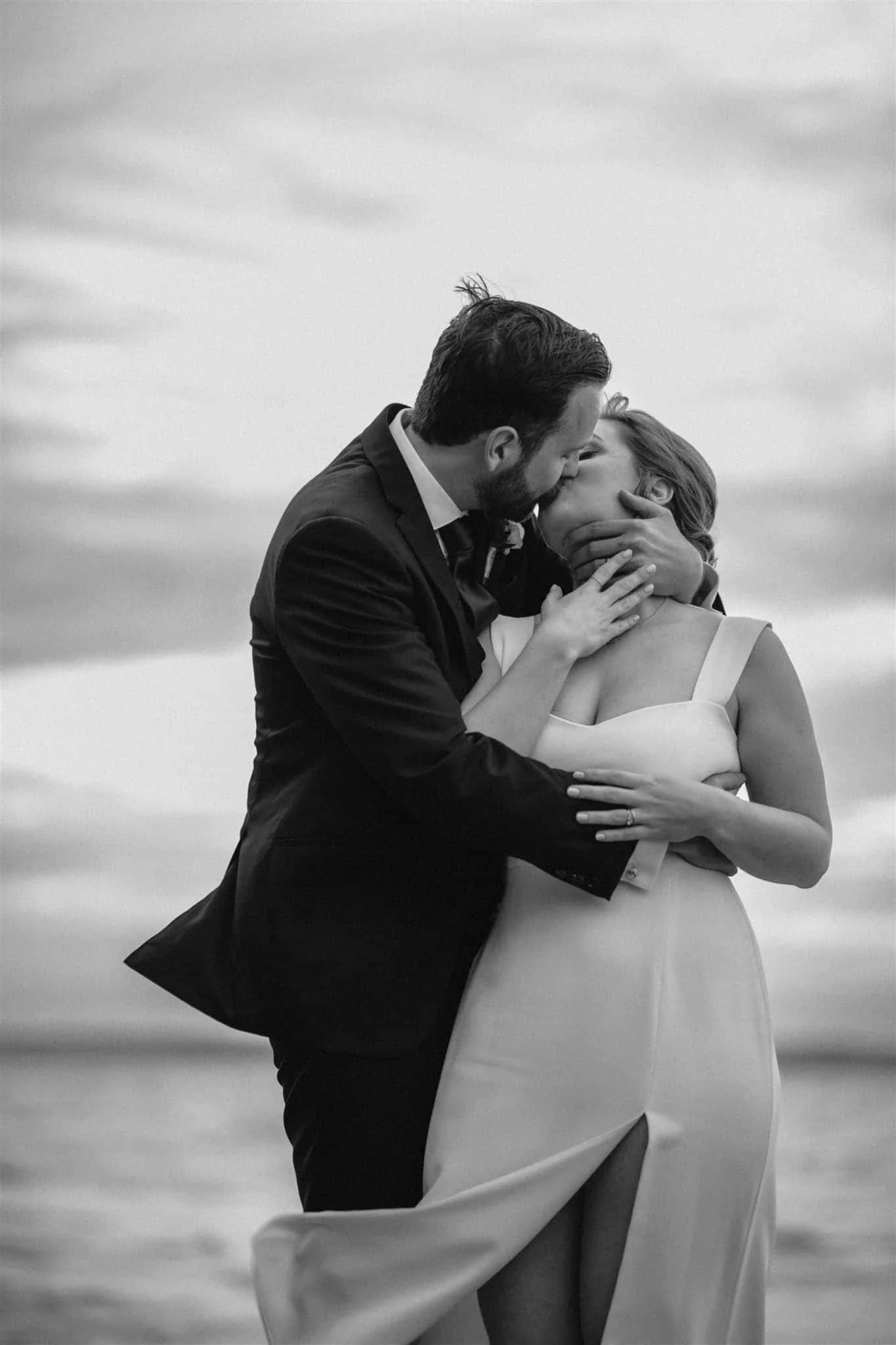 Black and white portrait of bride and groom kissing on Georgian Bay