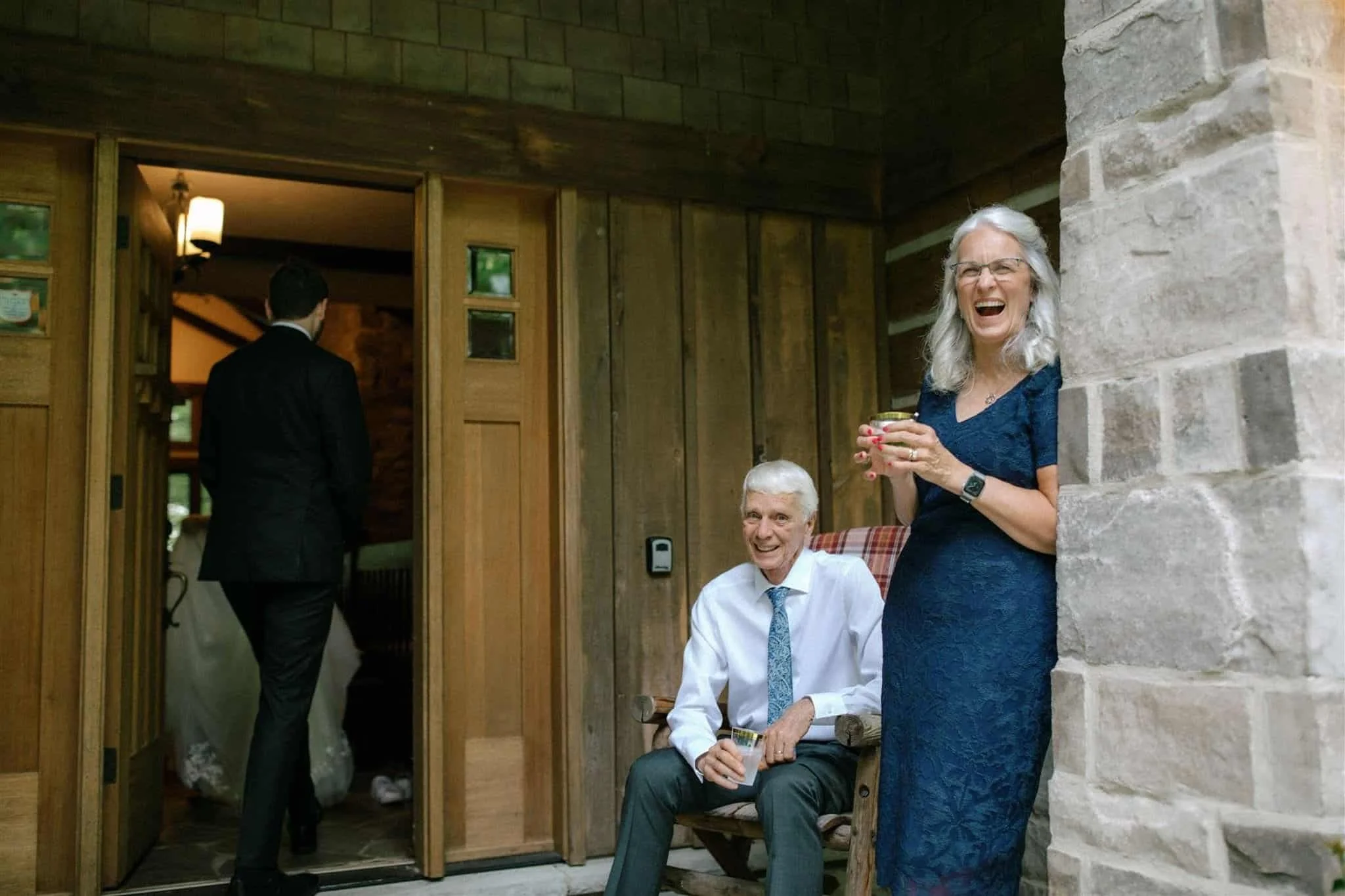 Groom's parents laughing on the porch of Serenity Cottage