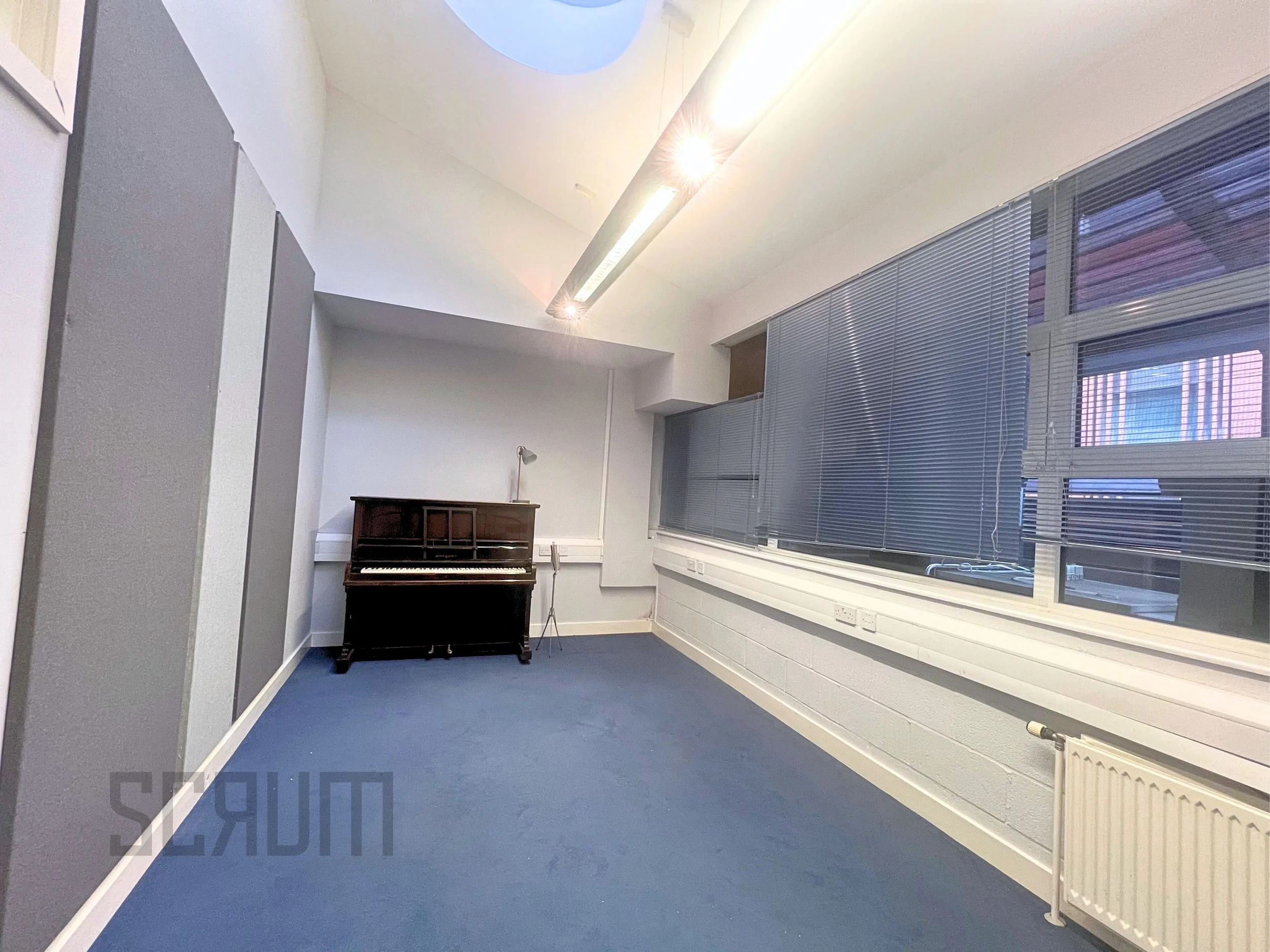 Audition studio with piano, as well as soundproofing on one wall