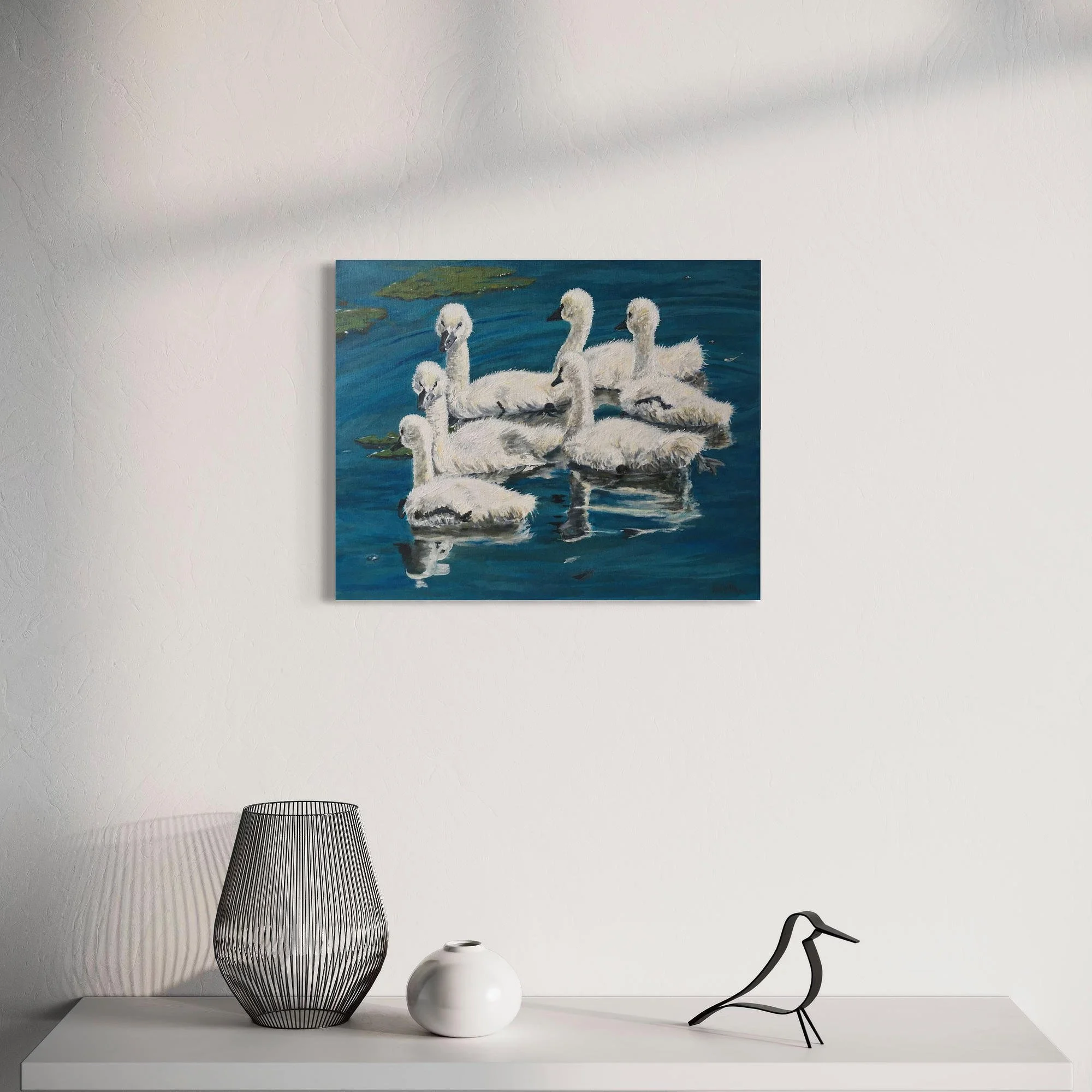 Peinture Les Cygnons de Juin encadrée au-dessus d’un meuble dans un intérieur clair