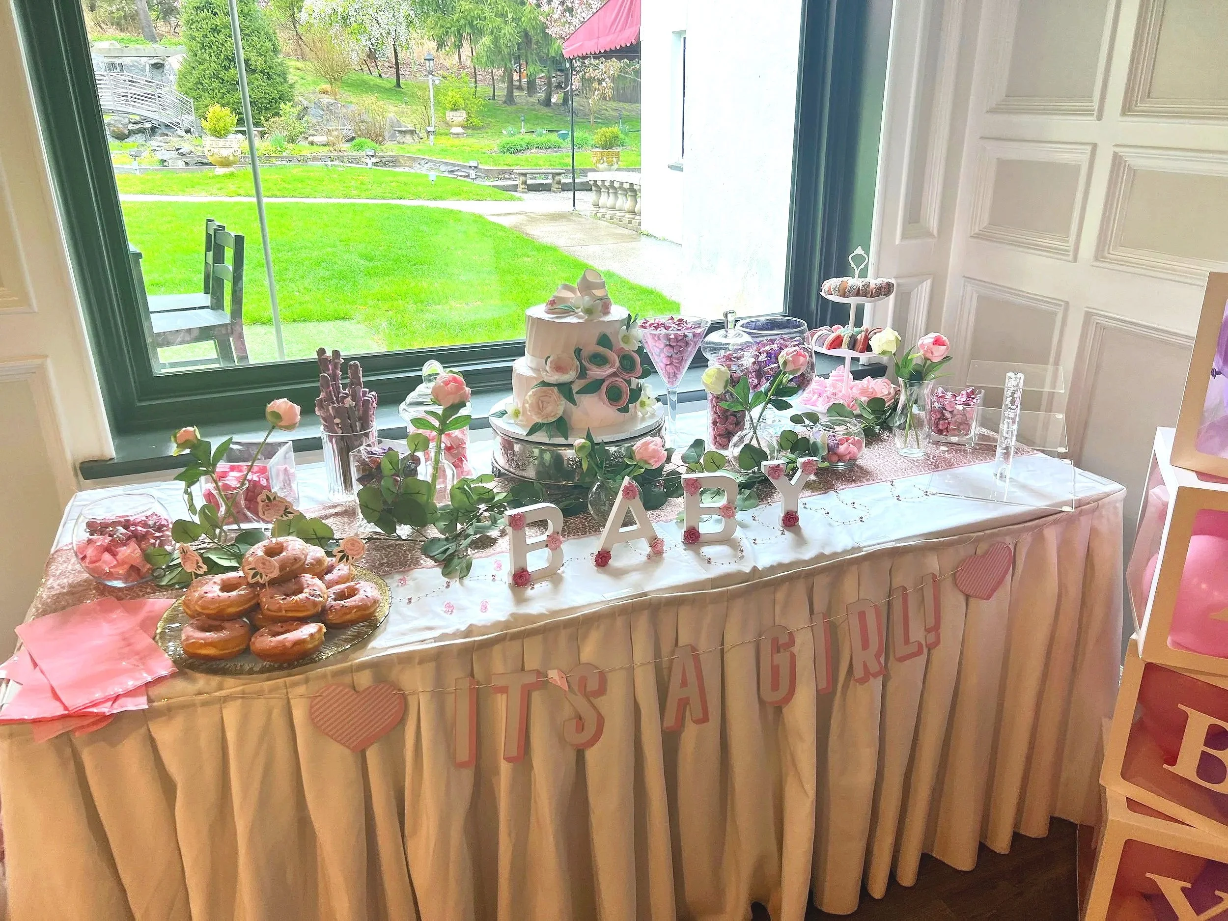 Bright and airy baby shower reception area decorated with floral arrangements.