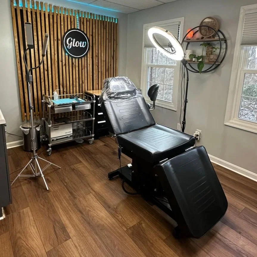 A modern tattoo studio room with a tattoo chair, ring light, and tattoo supplies. Tattoo studio room with ring light and tattoo chair.