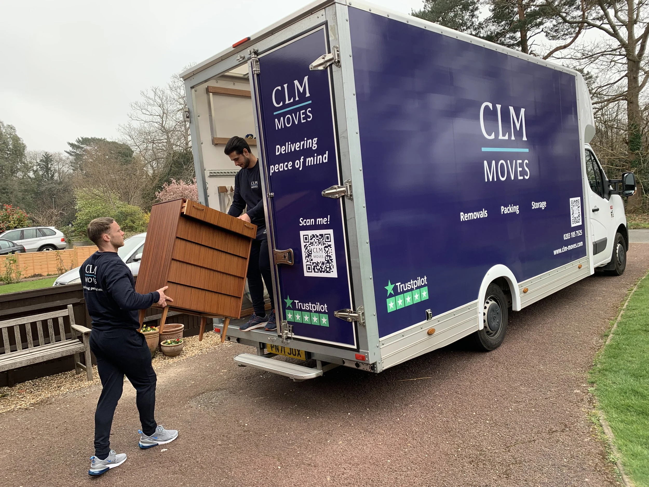 CLM Moves crew loading furniture into a branded van