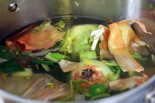 Vegetables cooking in a large pot.