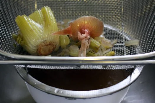 Straining out vegetables.