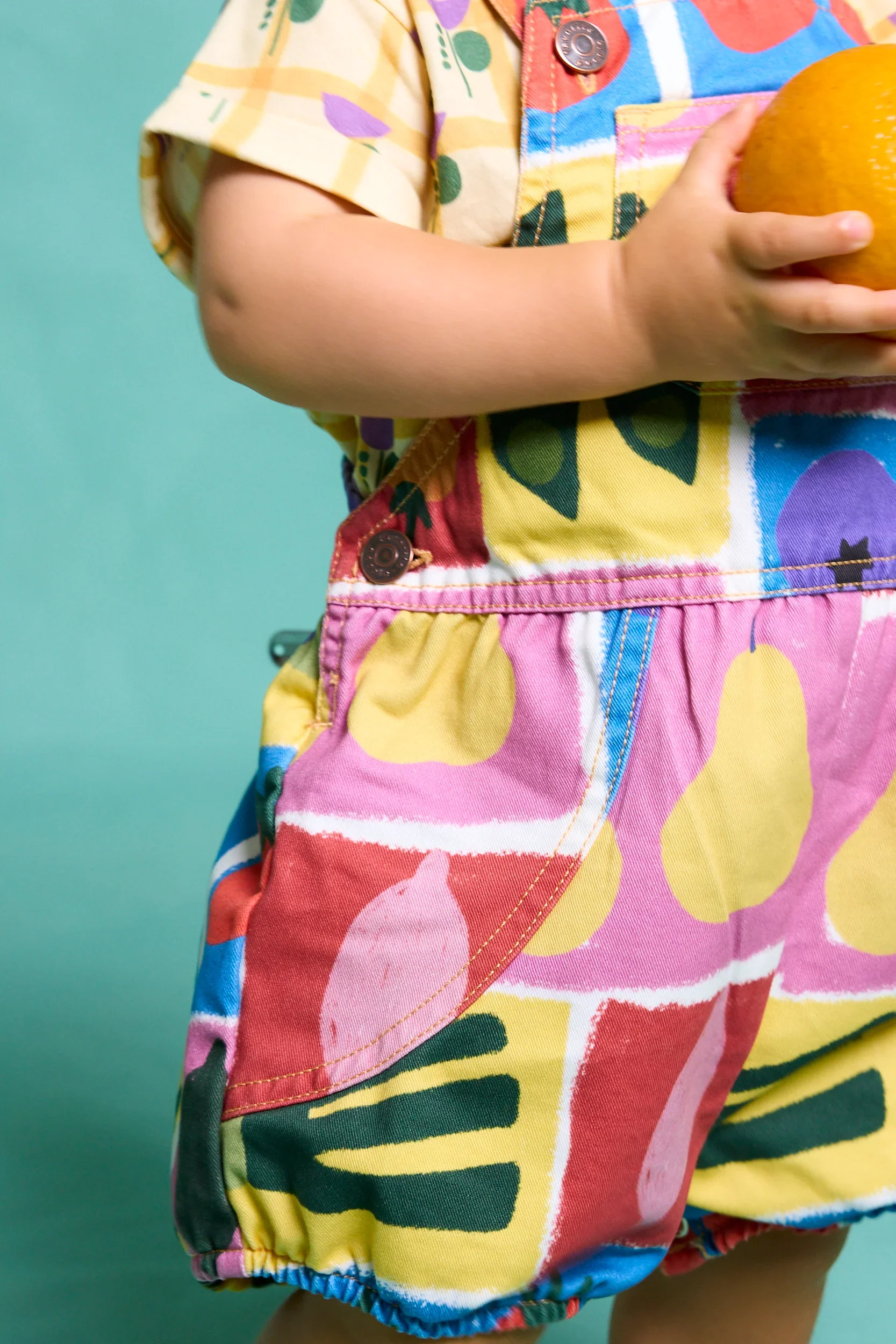 Bunter Baby Romper mit Obst- und Gemüseprint, verstellbaren Trägern und Druckknöpfen – aus Baumwolle. Favorite People Made in Portugal bei Cleo&Caesar Kindergeschäft Berlin