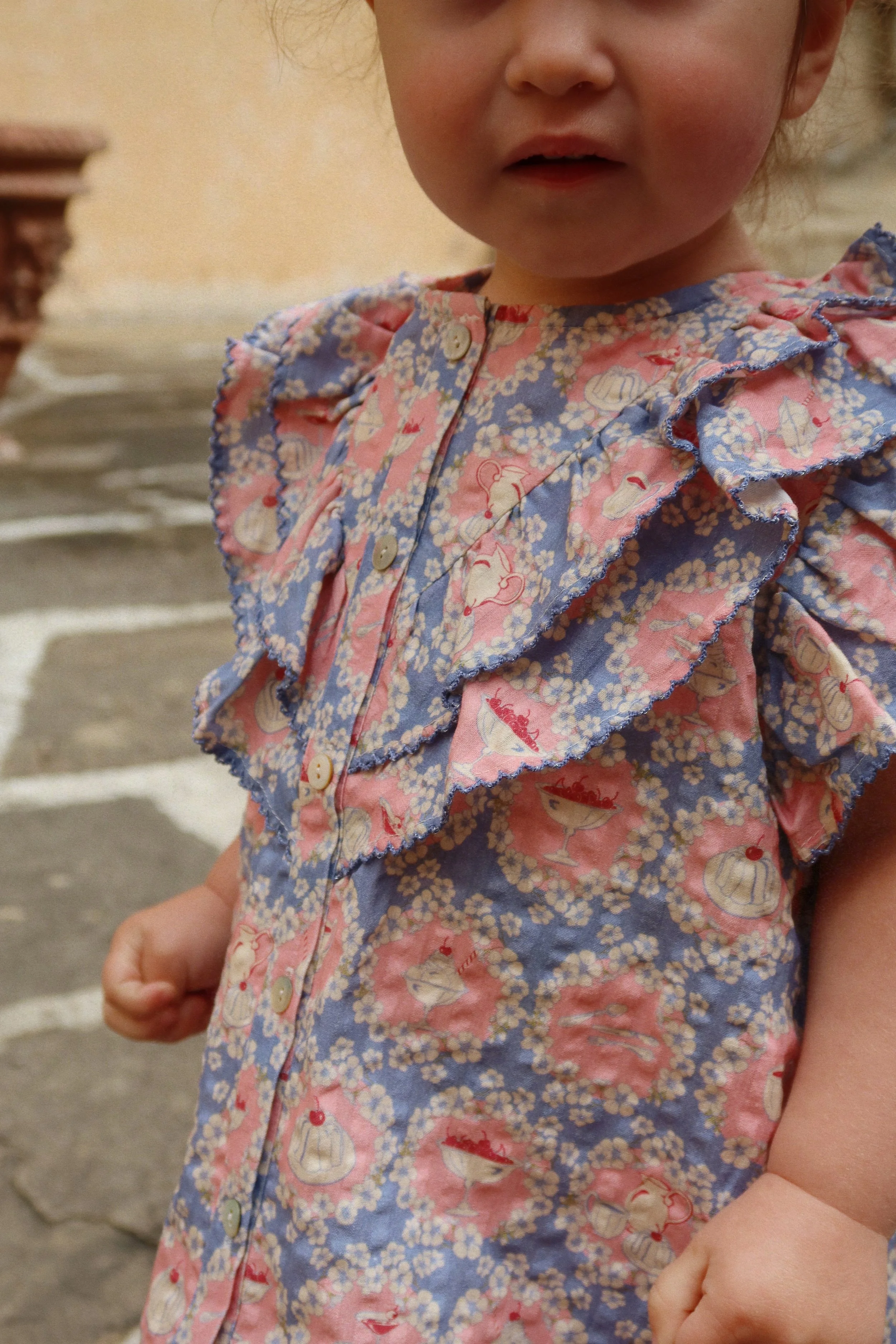 Weißes Kinder T-Shirt aus Bio-Baumwolle mit Rüschendetails und verspieltem Snack Time Print im Kids Concept Store Cleo&Caesar.