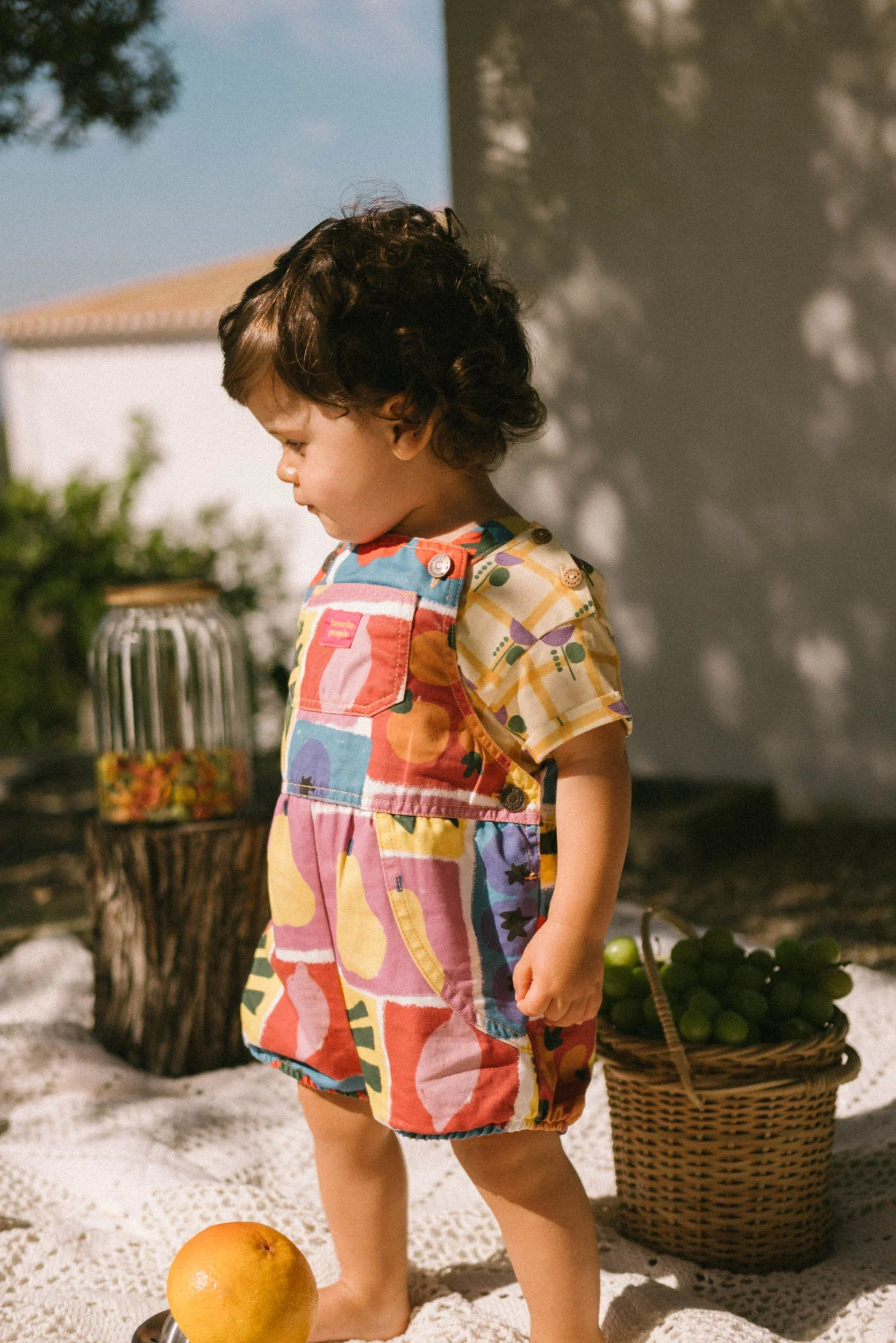 Bunter Baby Romper mit Obst- und Gemüseprint, verstellbaren Trägern und Druckknöpfen – aus Baumwolle. Favorite People Made in Portugal bei Cleo&Caesar Kindergeschäft Berlin