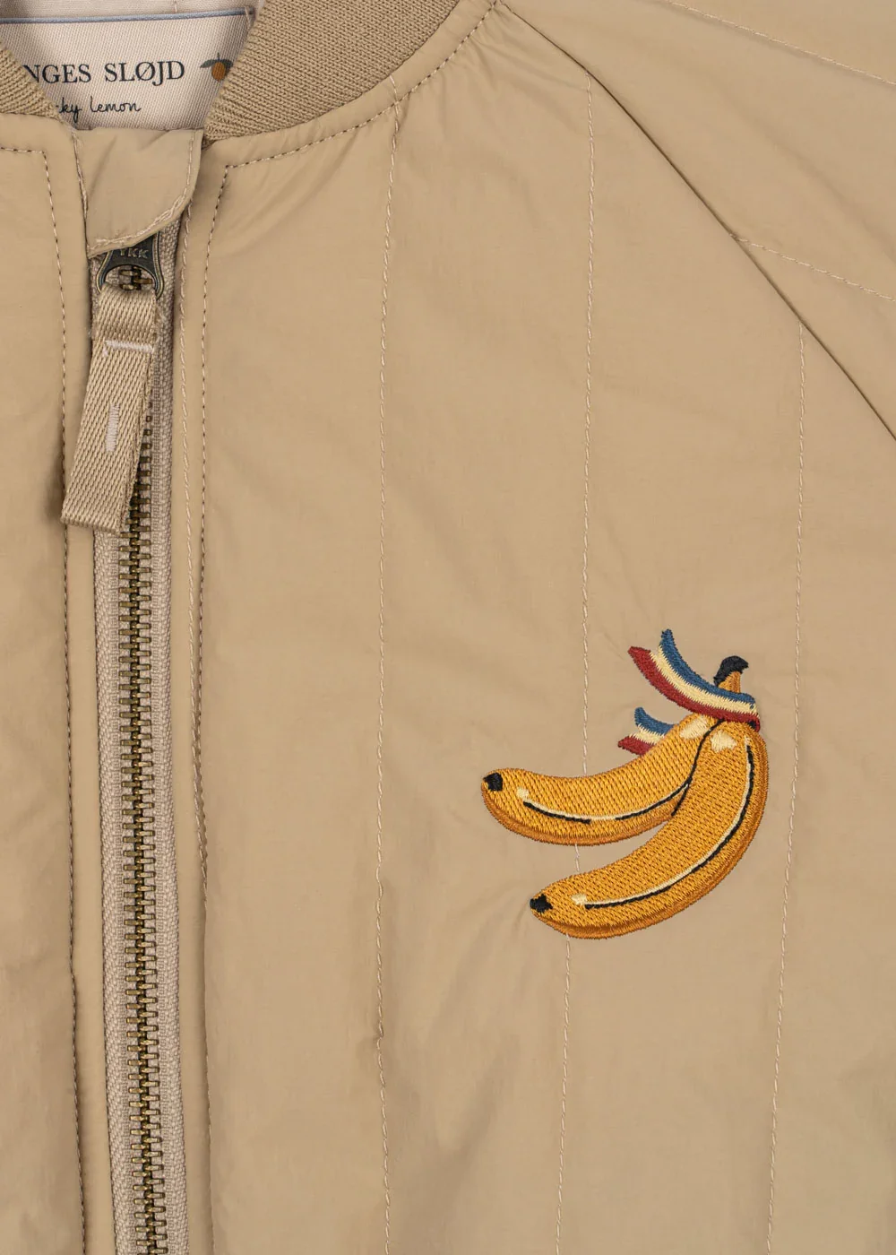 Juno Bomber Jacke Travertine für Kinder von Konges Sløjd – kuschelige, nachhaltige Kinderkleidung in Beige mit Herzprint, erhältlich bei Cleo&Caesar Kids Concept Store Berlin.