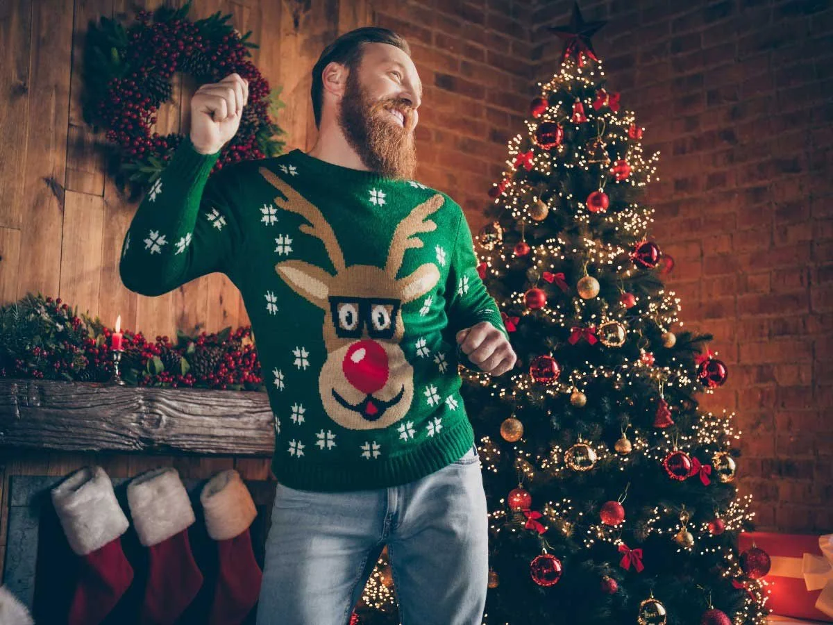 Hipster in a Rudolph Jumper by a Christmas Tree