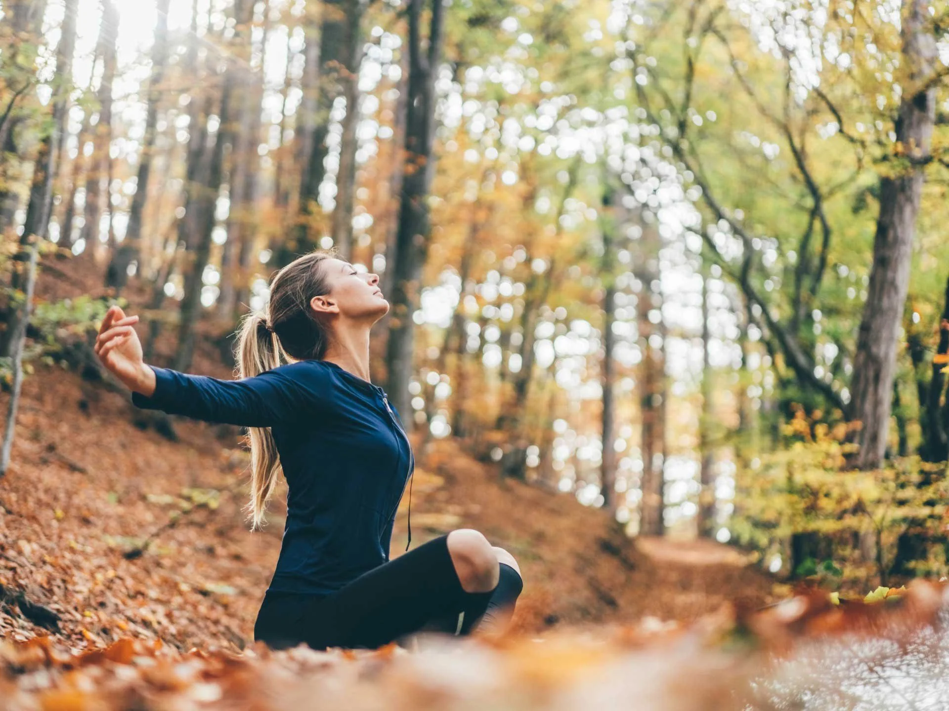 Woman practicing yoga in a woodland