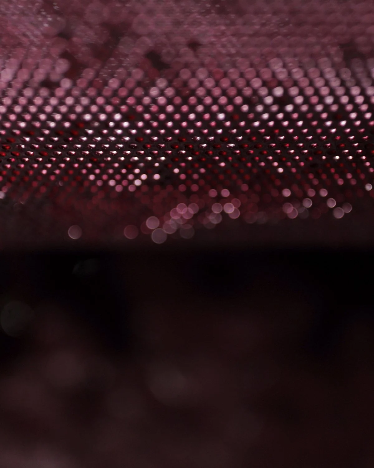 Light and droplets on the surface of a wine glass