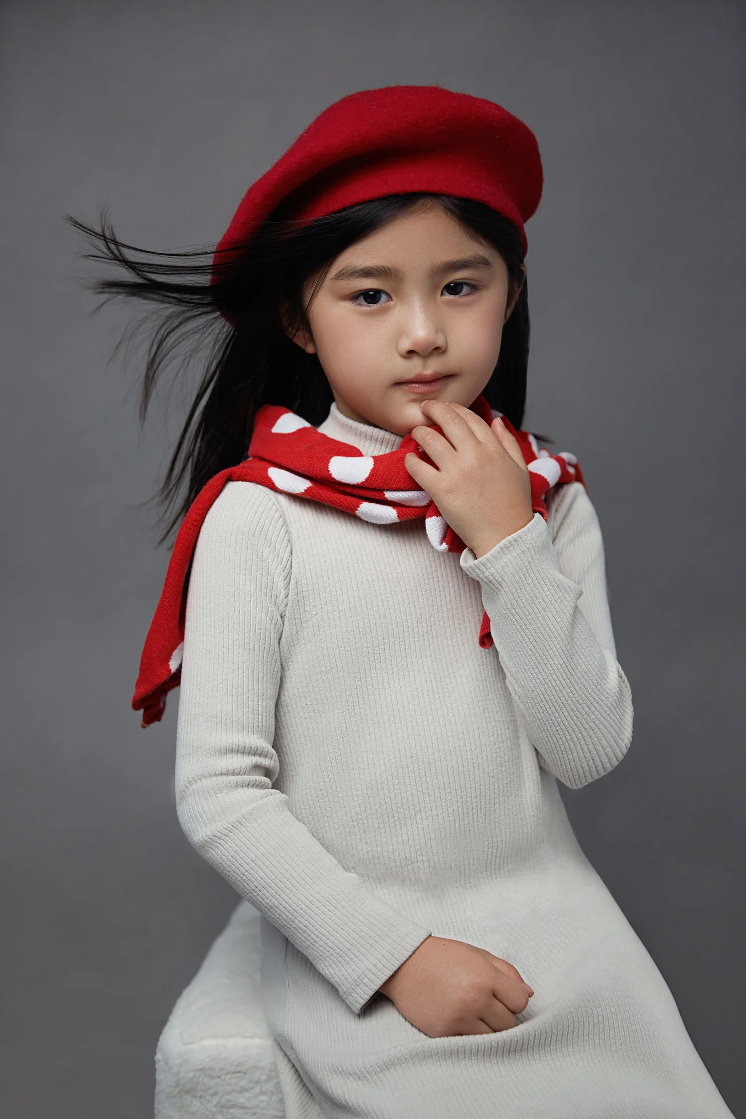 Little girl in a red beret and polka-dot scarf