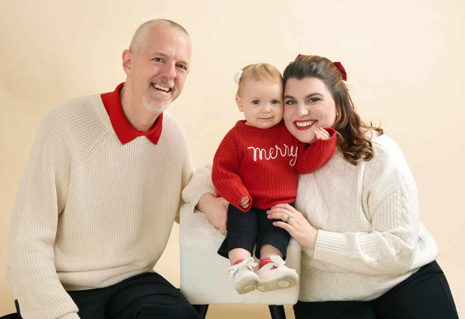 Grandfather, mother, and a baby in a red Merry sweater