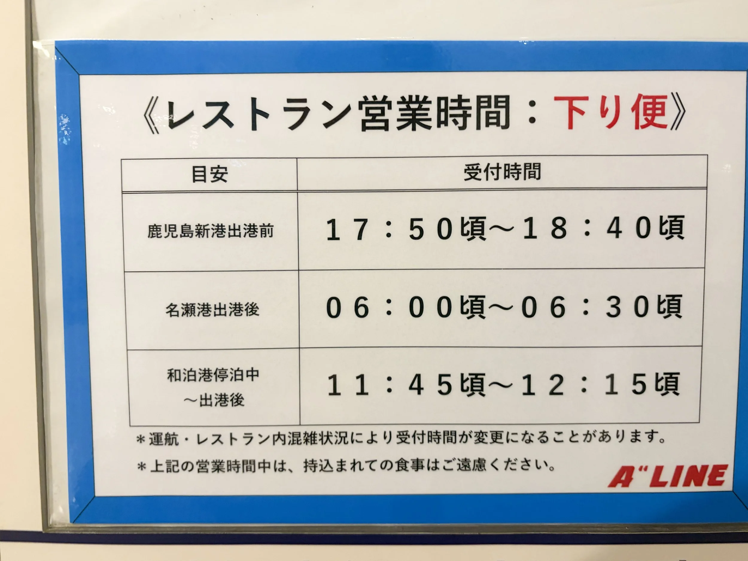 白い壁に、青い縁取りの案内板が掲示されています。中央上部に「《レストラン営業時間：下り便》」と大きく書かれています。下り便のレストラン受付時間として、鹿児島新港出港前は17時50分頃から18時40分頃、名瀬港出港後は6時頃から6時30分頃、和泊港停泊中から出港後は11時45分頃から12時15分頃と案内されています。下部には、運航状況などで時間が変更される場合や、営業時間中の食事持ち込みを控える注意書きがあります。
