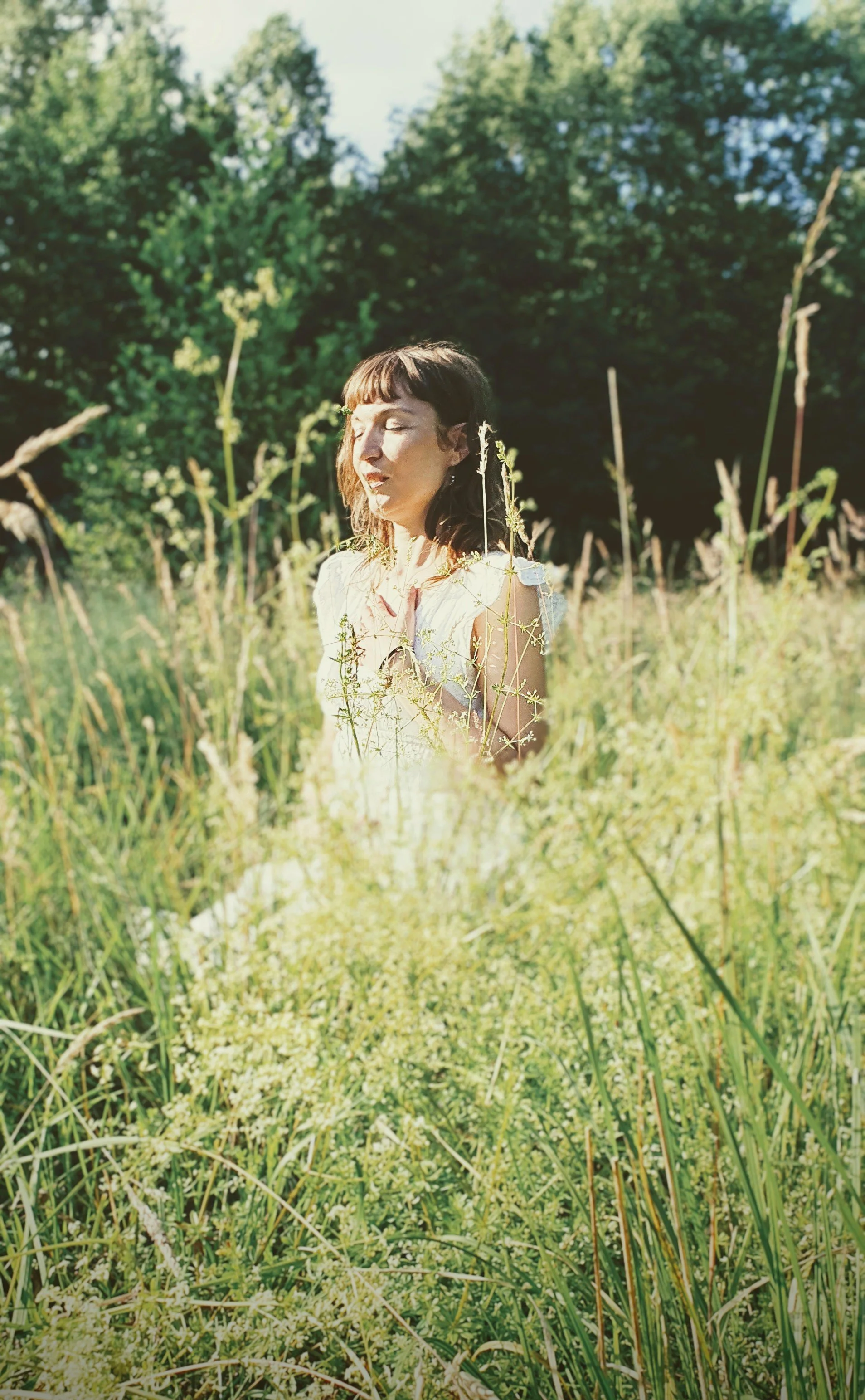 Frau meditiert auf einer Wiese mit der ThetaHealing Meditation