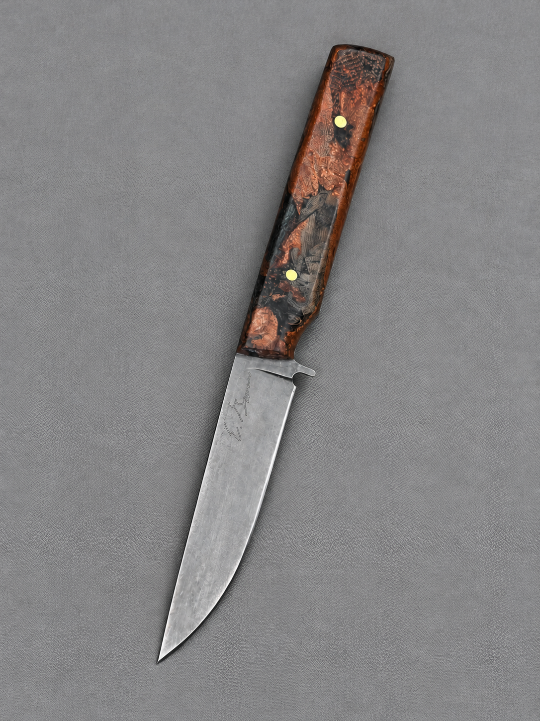 Elegant handmade knife on gray fabric.png