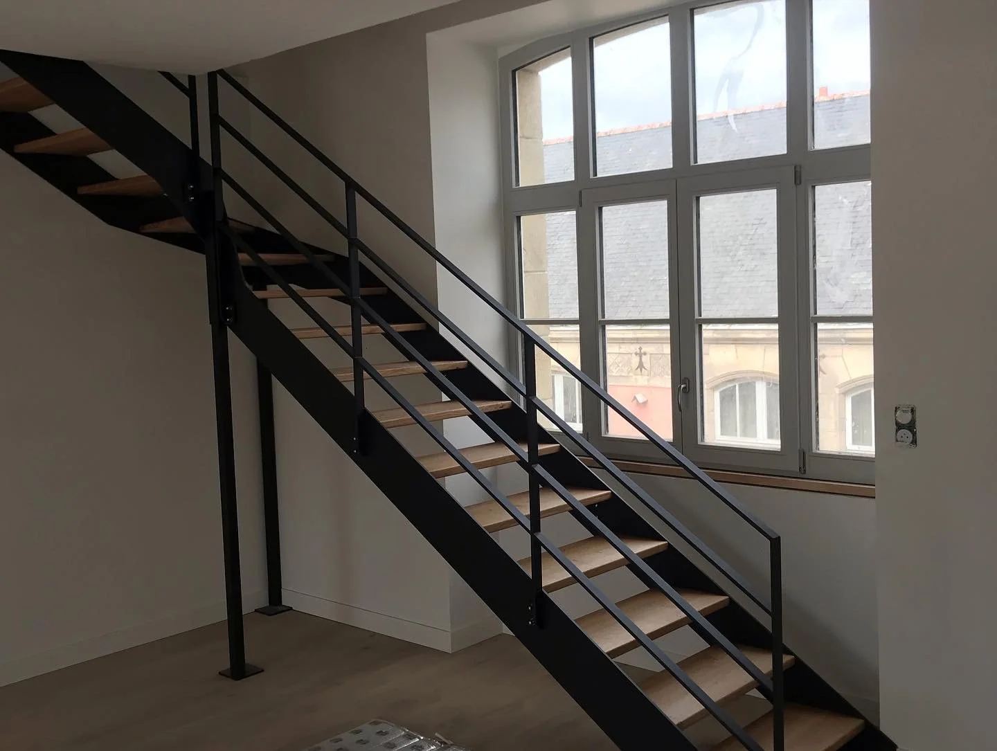 Installation d'un escalier métal avec marche en chêne.