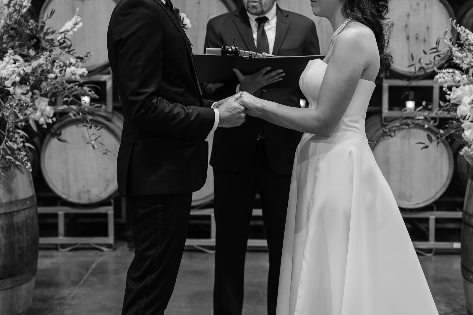 Couple holds hands during their ceremony at Domenico Winery.