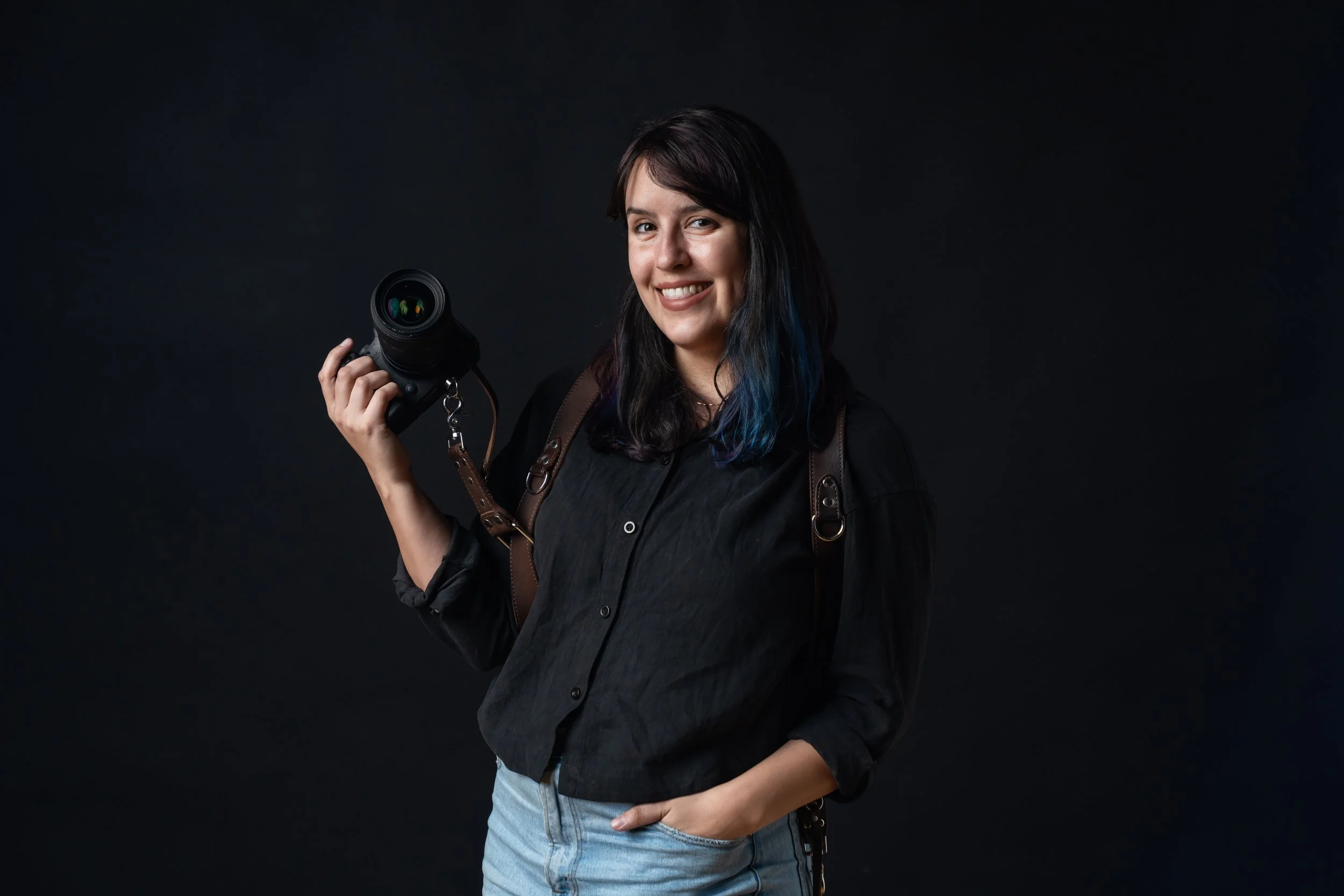 San Diego wedding photographer Kelsey Nevell poses with a camera.