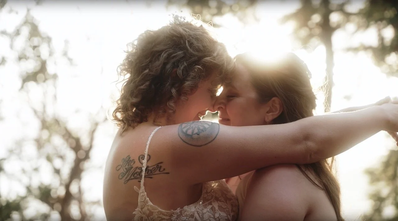 Two brides face each other during golden hour on their wedding day.
