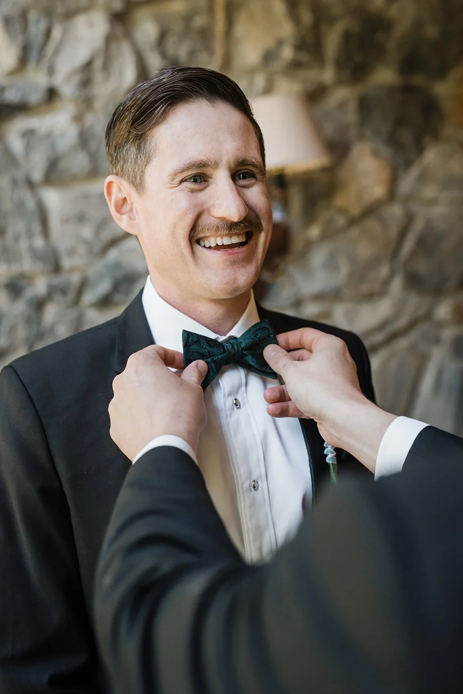 A groom gets his tie adjusted before his wedding ceremony in San Francisco.