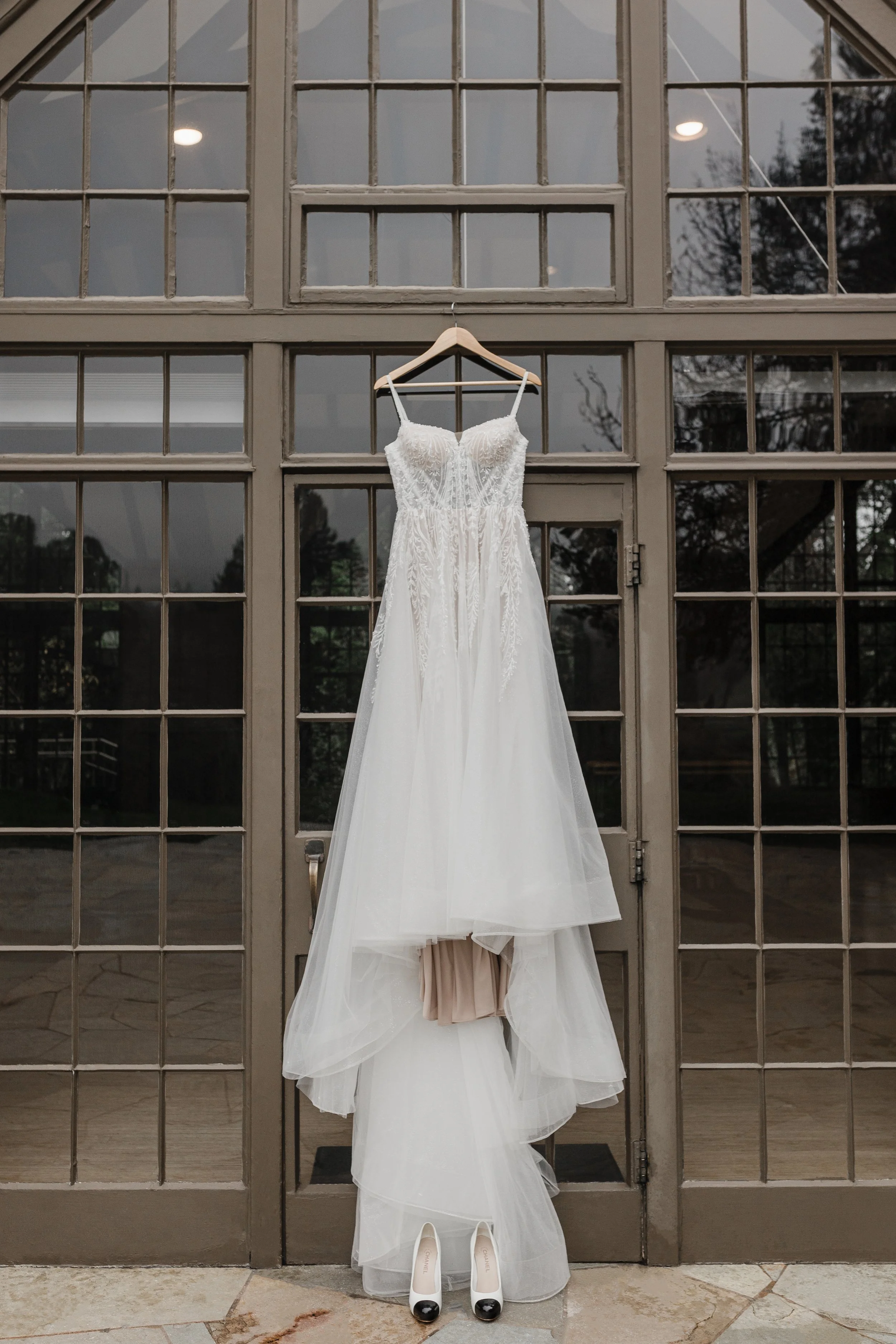 Wedding dress hanging on a wall of windows at Brazilian Room at Tilden Park.