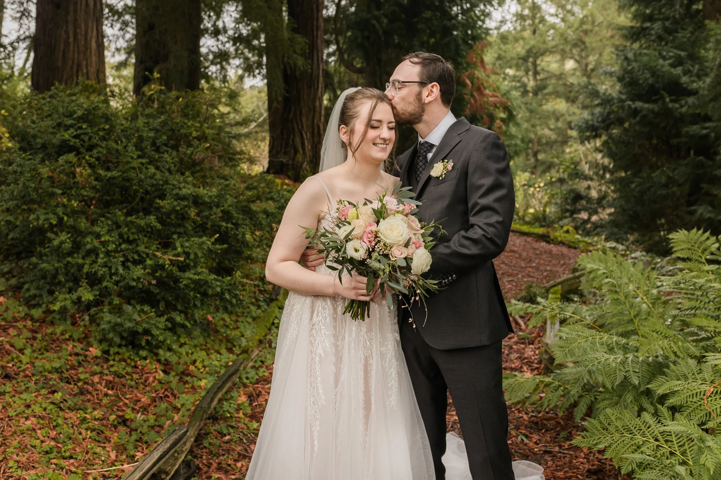 A couple stands in a redwood forest at The Brazilian Room at Tilden Park.