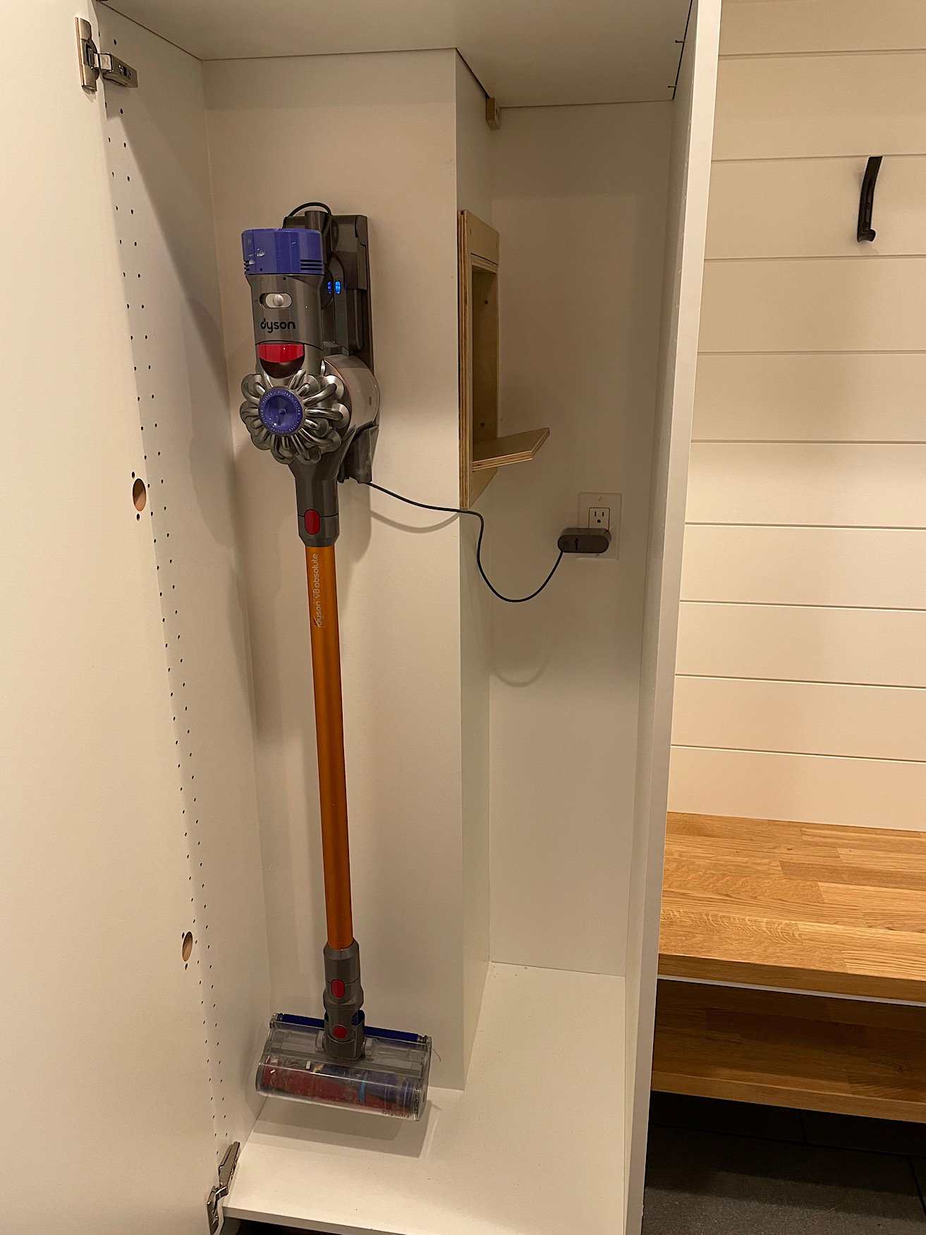 After - closet complete (shelves being added later) with power for Dyson vacuum, and an access door into the laundry shoot to drop in clothes as they come off in the mud room