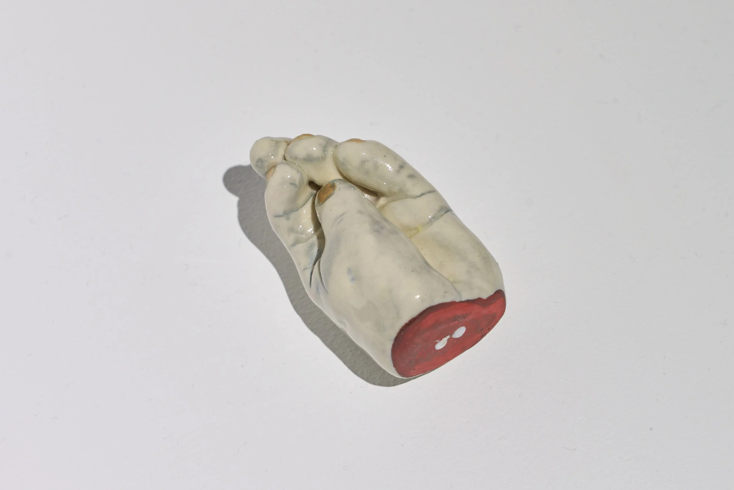 Close up view of another infant hand object,  the hand is palm up, the fingers curling in.