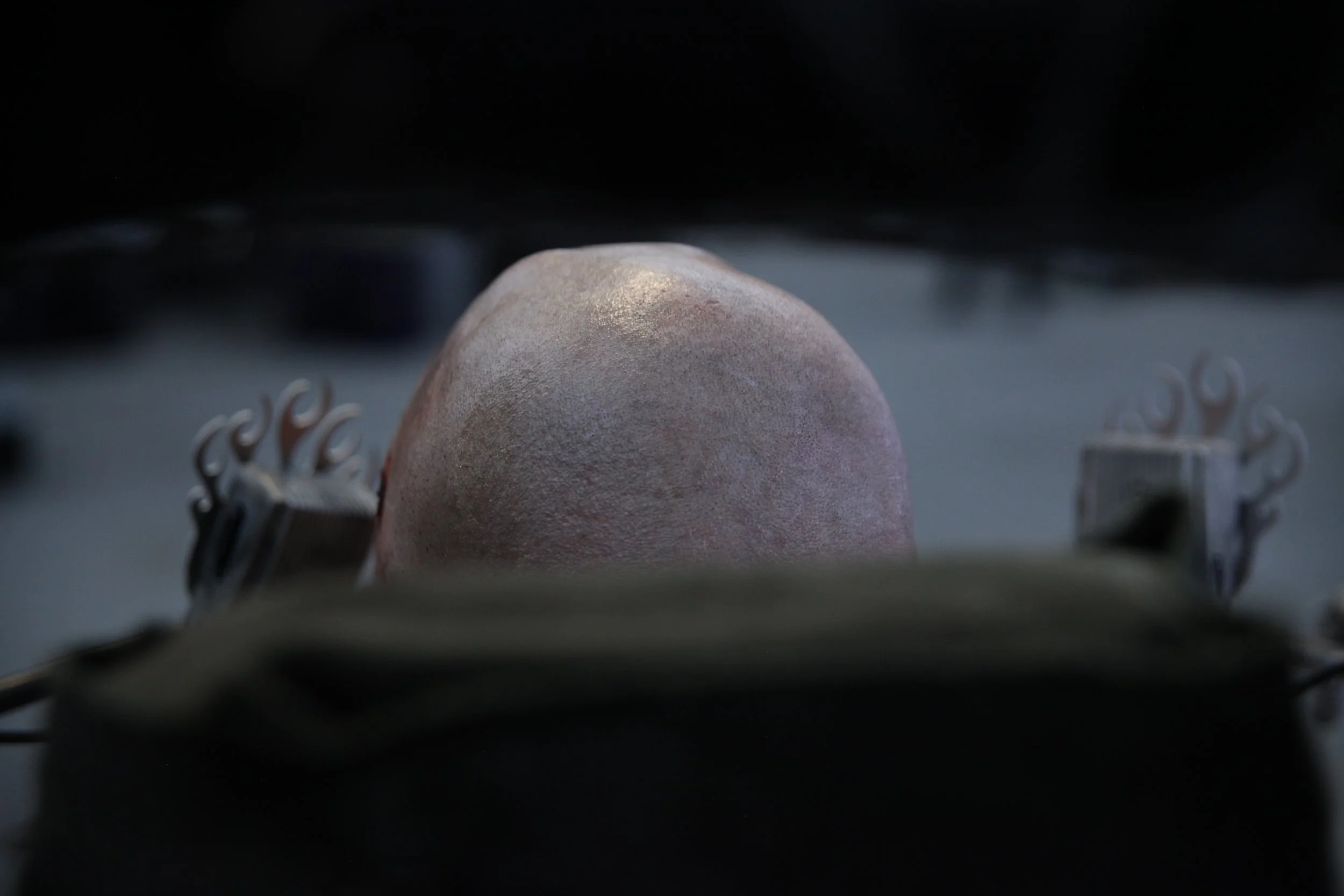 My grimey bald head is shown from behind the apocalyptic power wheelchair head rest.