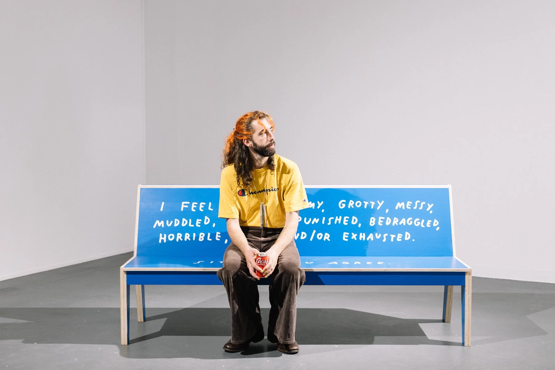 Someone at the opening sitting on the bench with a drink