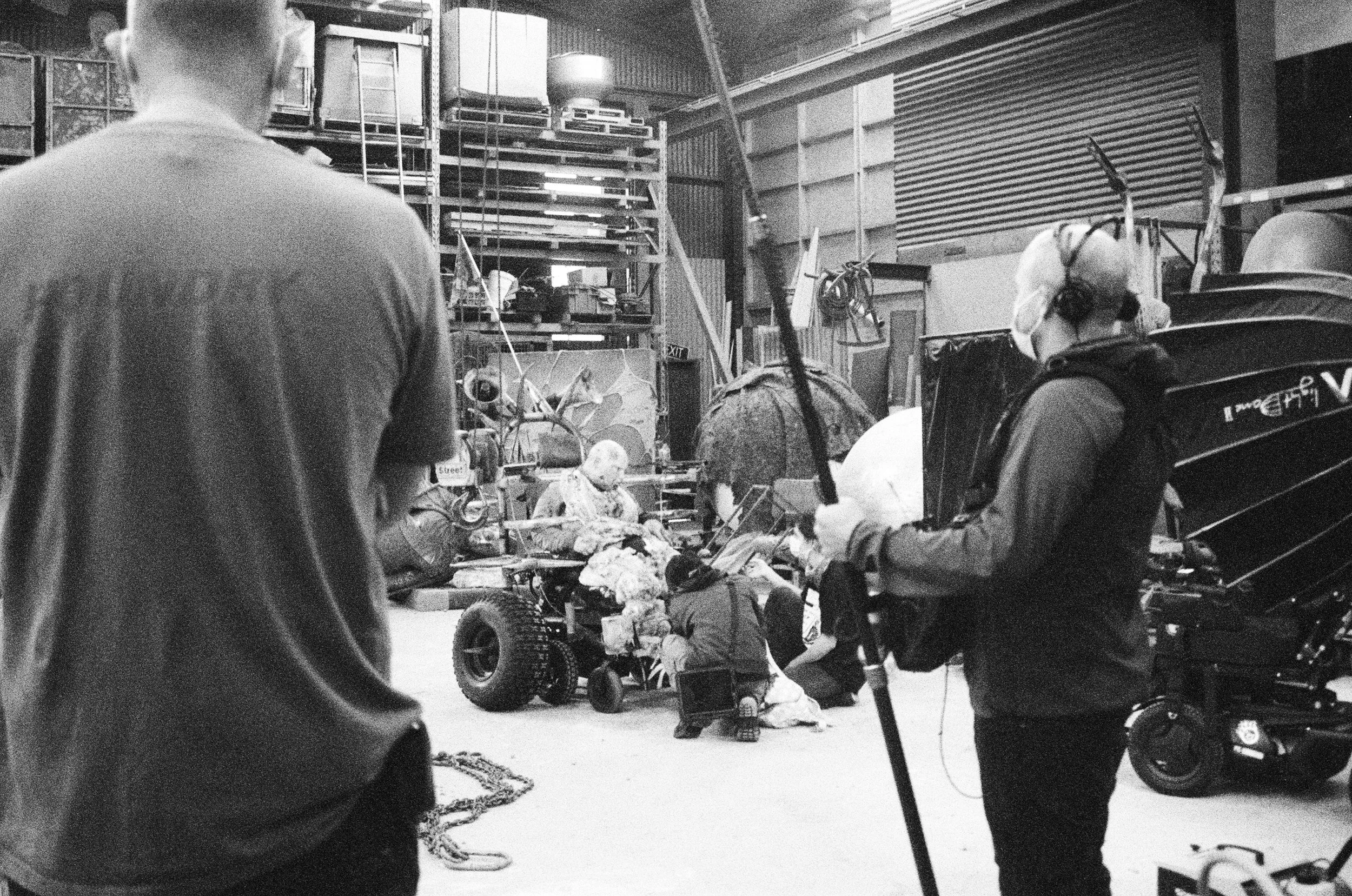 Two support workers kneel in front of me wearing masks in between shots. There are two crew members standing nearby