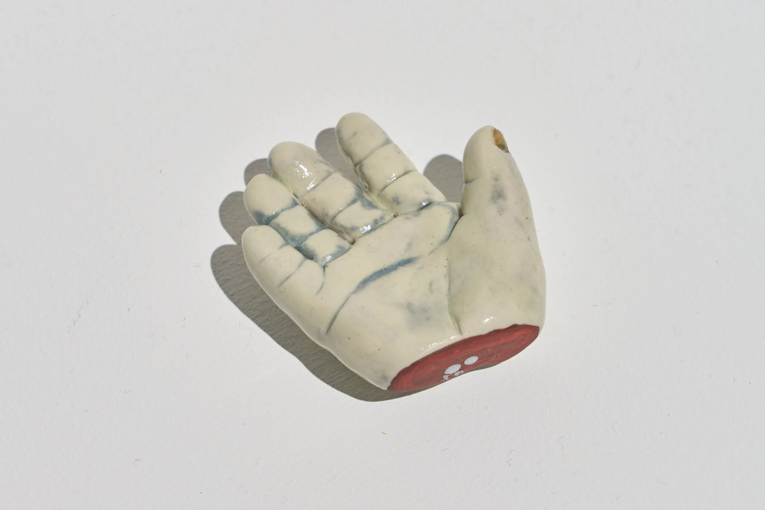 Close up view of another severed infant hand, the hand is positioned with fingers spread and palm open.