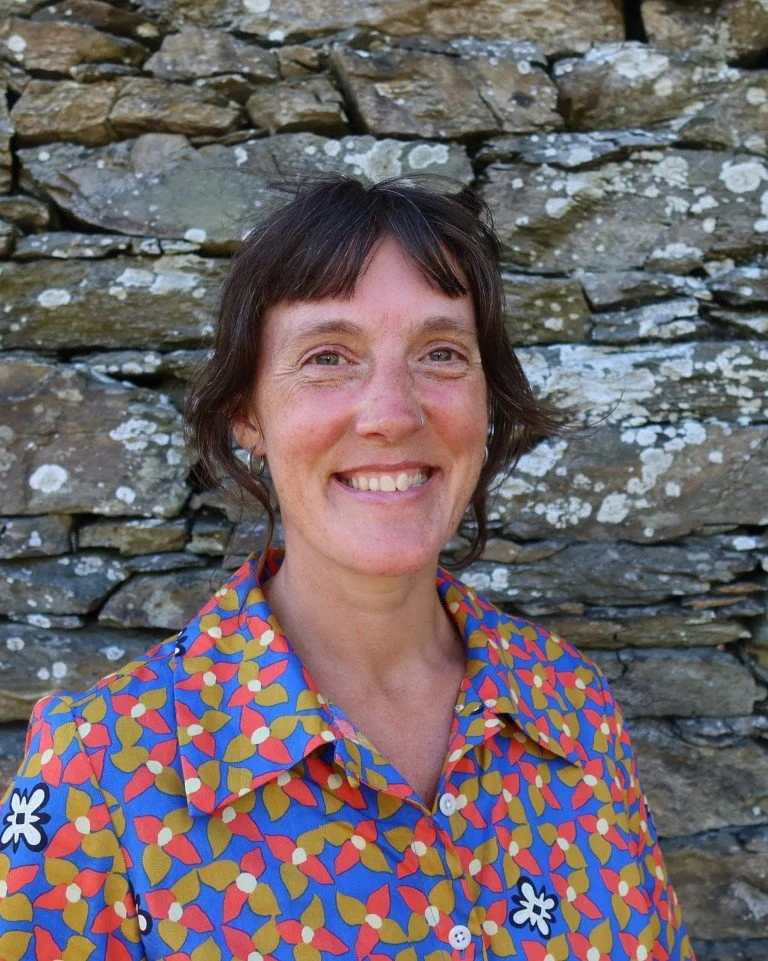 Nes smiling wearing a brightly coloured dress