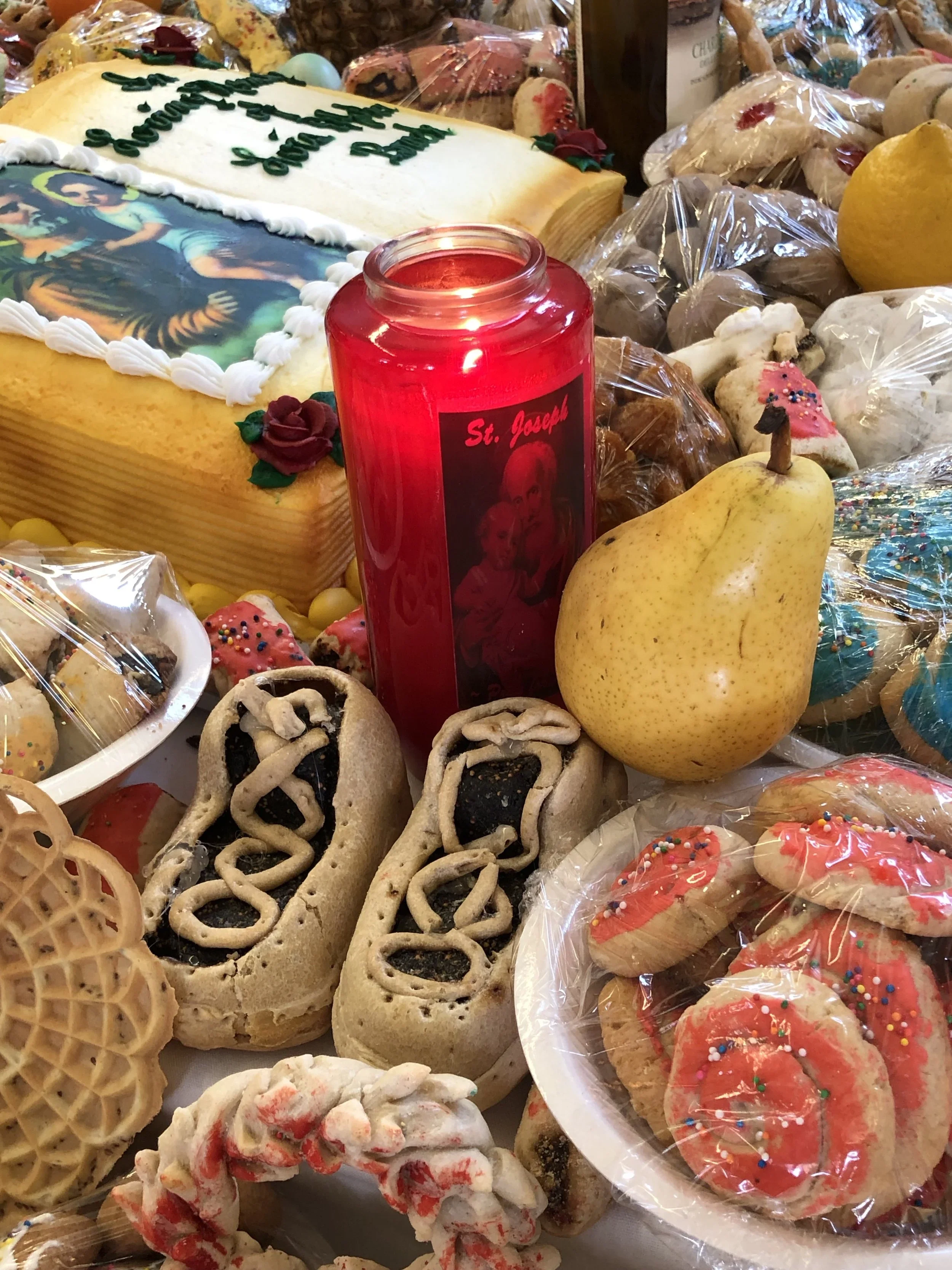 St. Joseph Altar with a red candle burning, food, and offerings.