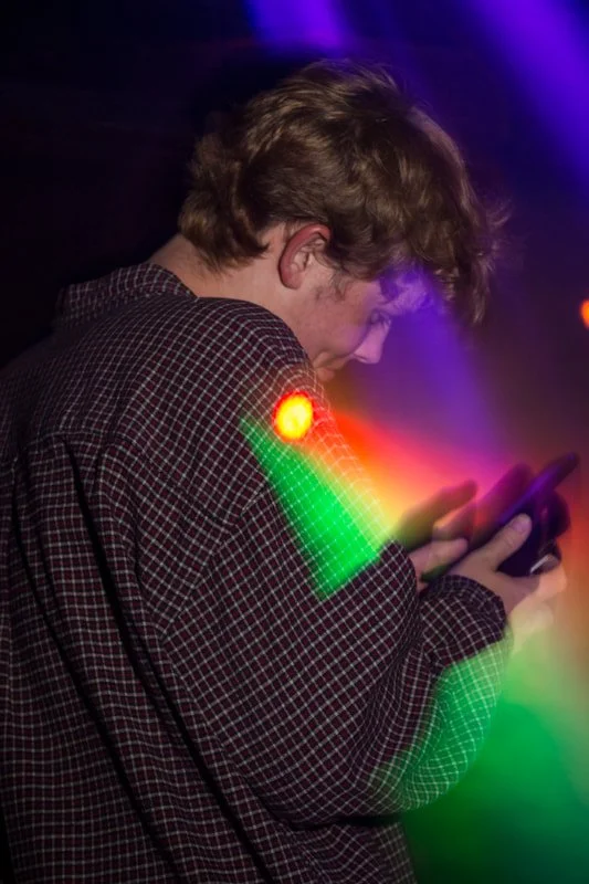 A Delta Zeta guest smirks at his phone.