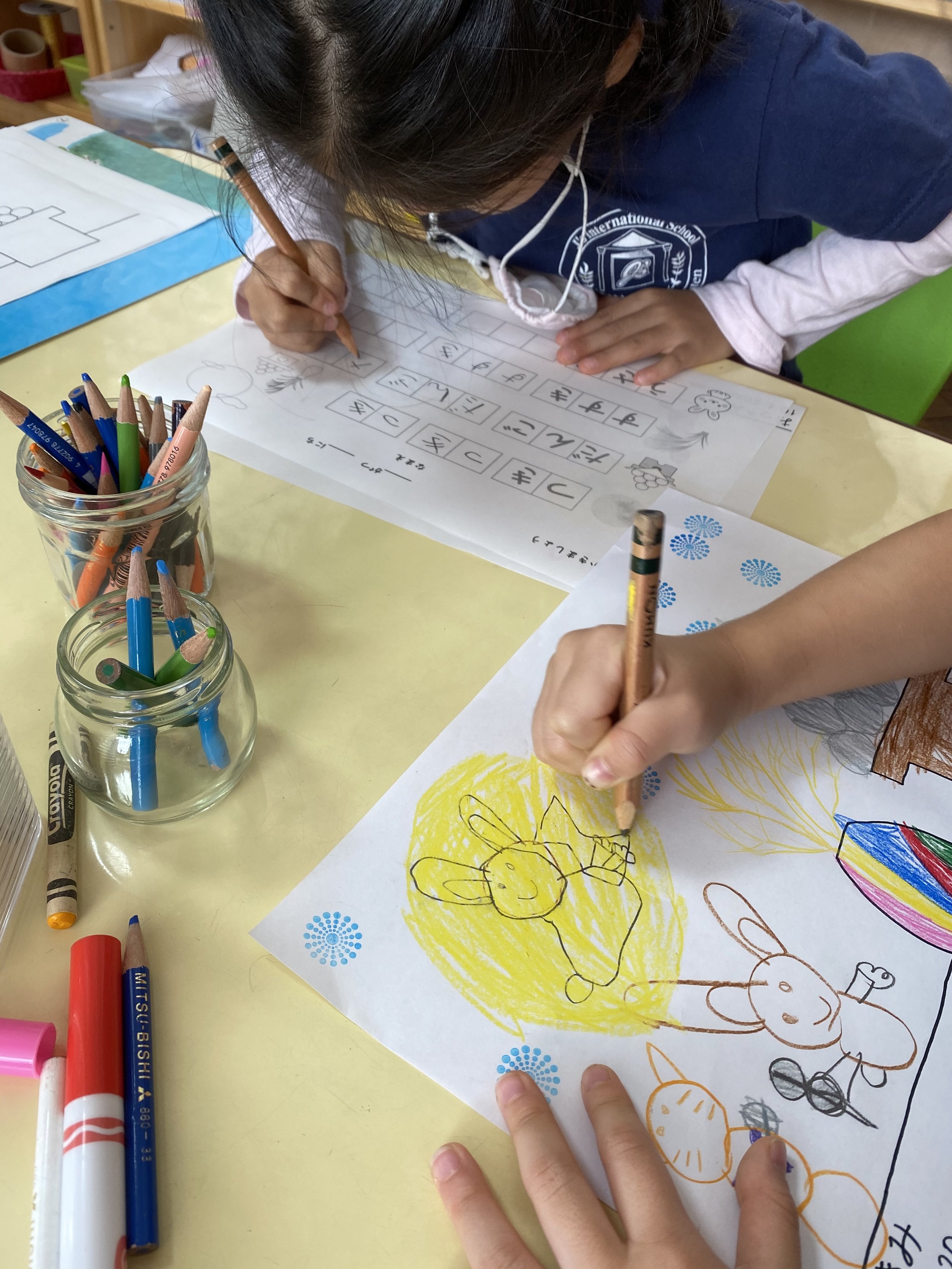 Children drawing a rabbit and moon for otsukimi. children writing hiragana.