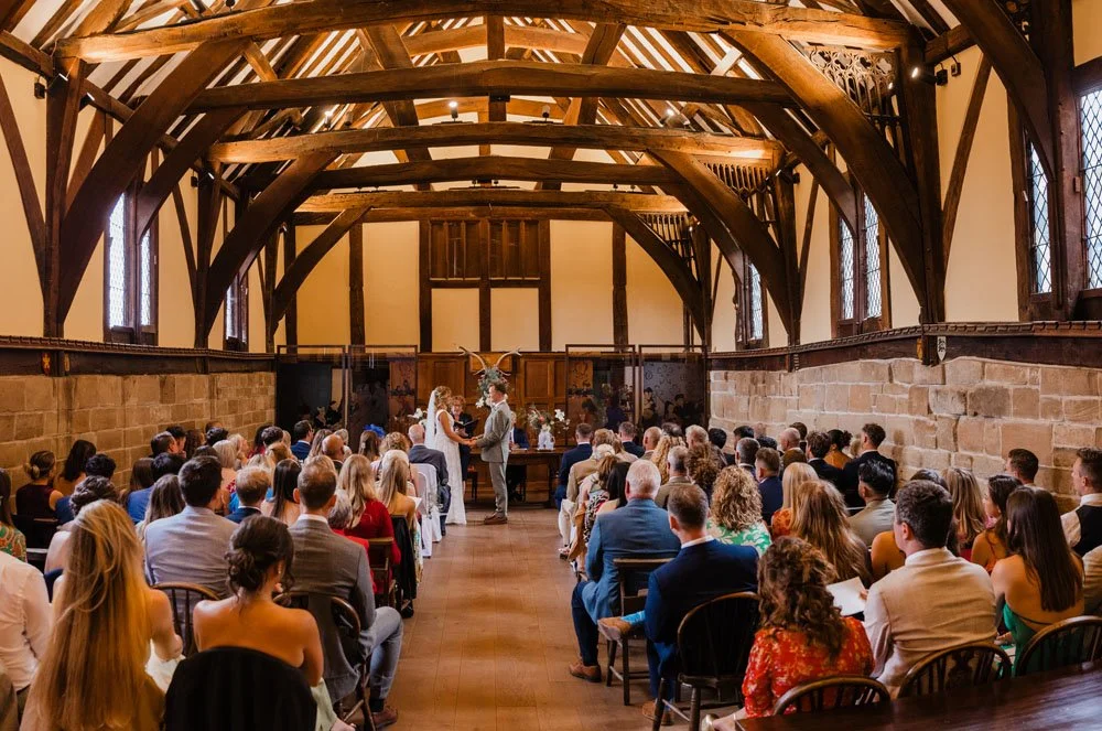 a bride and groom exchanging vows in the great hall at the Lord Leycester