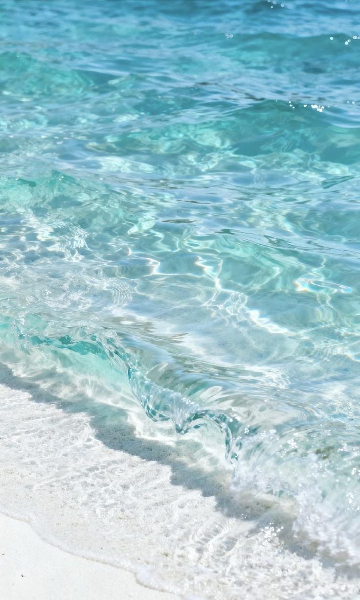 Clear turquoise water washing over pale sand at the shoreline.