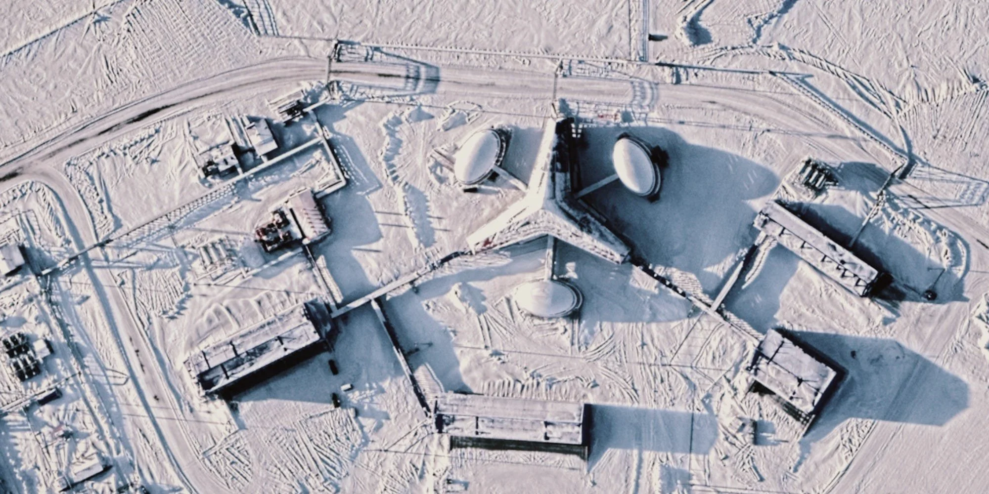 A satellite of a star-shaped building covered in snow.