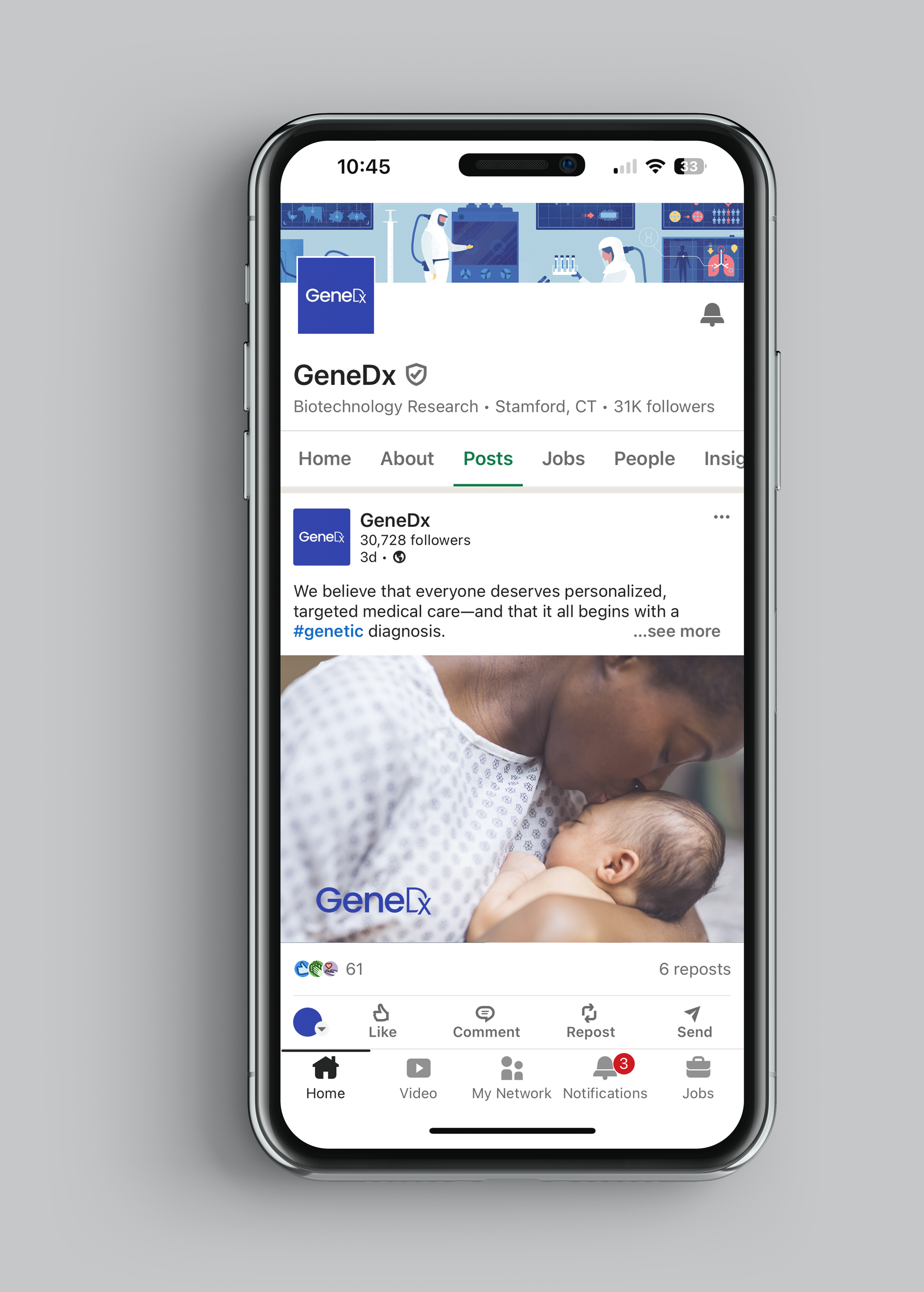A smartphone displaying a Facebook page for GeneDx, a biotechnology research company, with a post showing a healthcare professional holding a baby, emphasizing personalized genetic diagnosis.