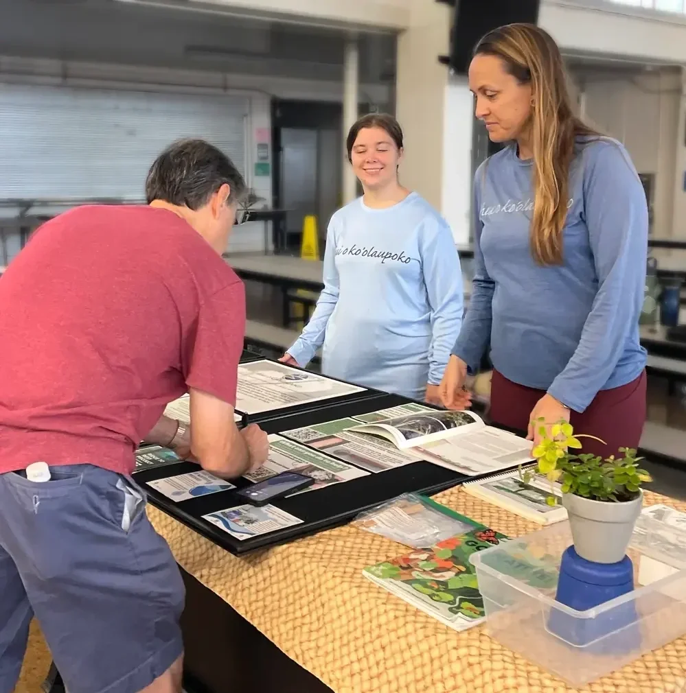 Hui o Koʻolaupoko sharing their projects that protect ocean health through restoring ʻāina with a community member at the Smart Yards 2024 Workshop hosted by Mālama Maunalua and 3Rwater