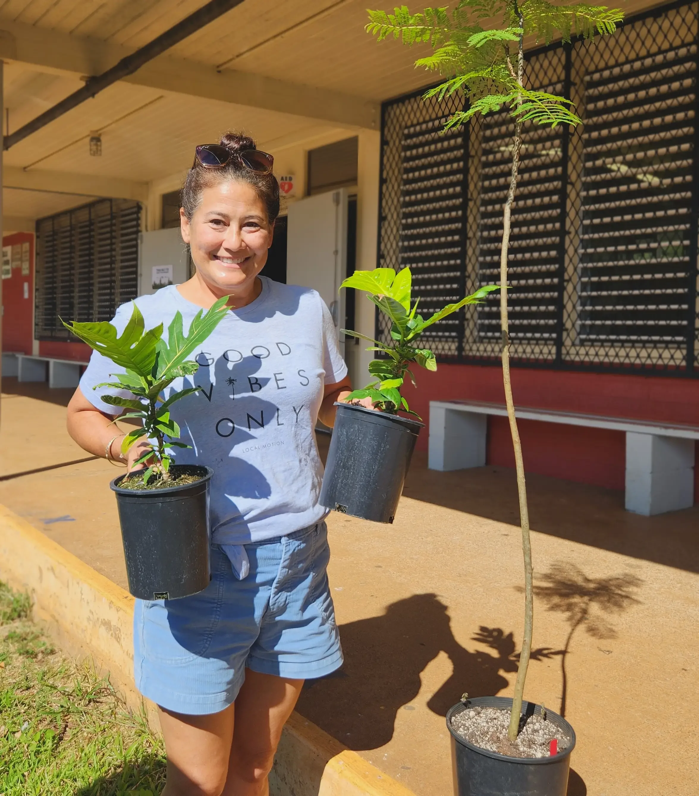 A happy community member with free garden plants ready for their forever homes at the Smart Yards 2024 Workshop hosted by Mālama Maunalua and 3Rwater