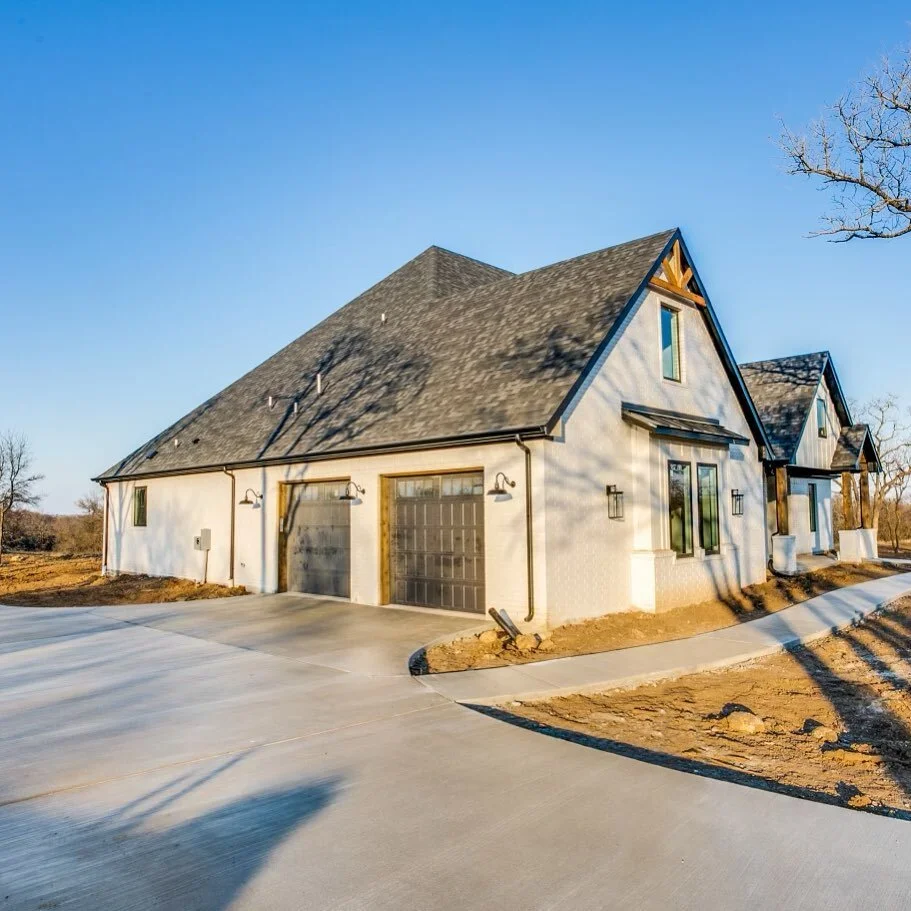 We love the long driveway and detailing of the garage doors! #driveway #garage #garagedoors #wooddetailing #ruggedoaksconstruction #customhomestexas