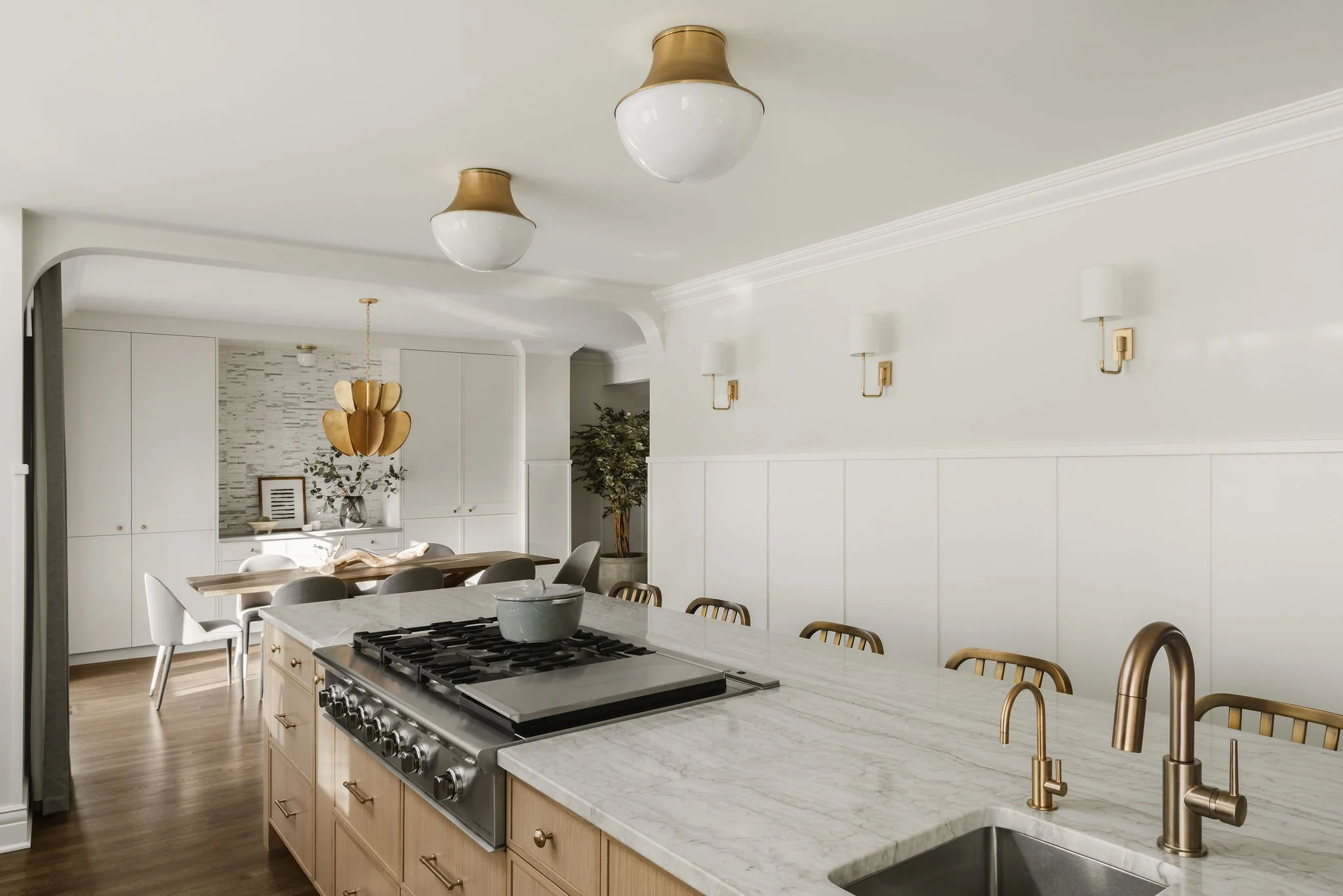 second open concept kitchen with oversized island and gold brass finishes