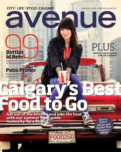 Cover of Avenue magazine featuring a woman sitting on the hood of a red car, holding a food container. The magazine is titled 'Avenue' and highlights Calgary's best food to go, with other headlines about bottles of beer, patio primer, and summer events.