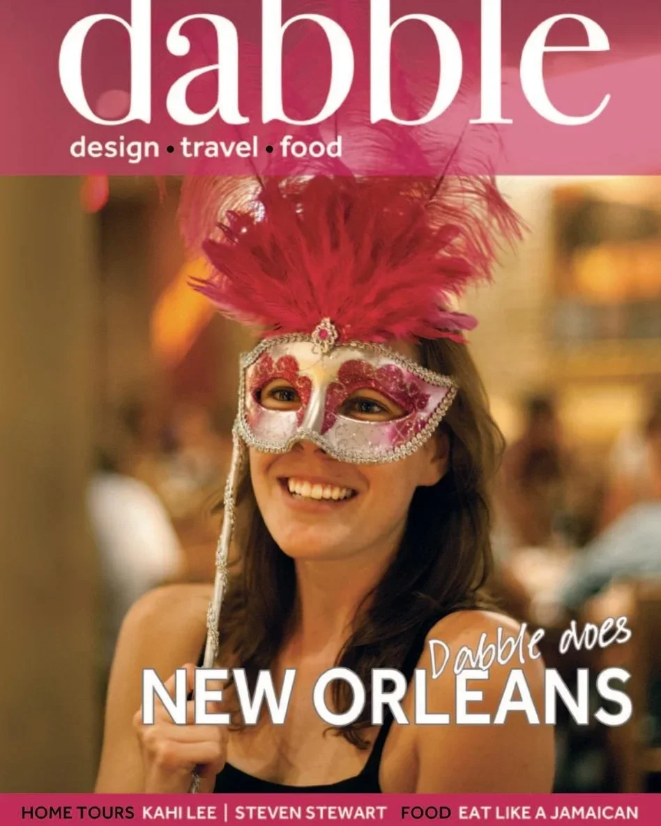 Magazine cover for 'Dabble' featuring a woman in a colorful carnival mask with feather decorations, smiling in a festive setting, with headlines about New Orleans travel, food, and home tours.